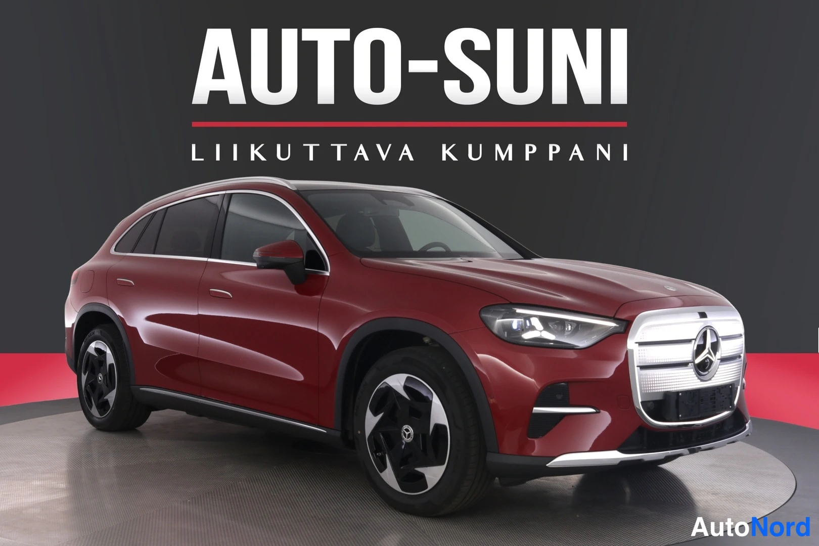 Etuviisto, nokka oikealle: Mercedes-Benz GLC -maasturi etuviistosta oikealta, tummanpunainen kori ja hopeiset pyöränvanteet studiotaustaa vasten.