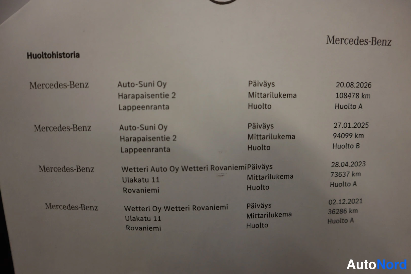 Muu: Huoltobistoria-dokumentti Mercedes-Benz -huolloista, joissa päiväykset, mittarilukemat ja huoltotyypit vuosilta 2021–2026.