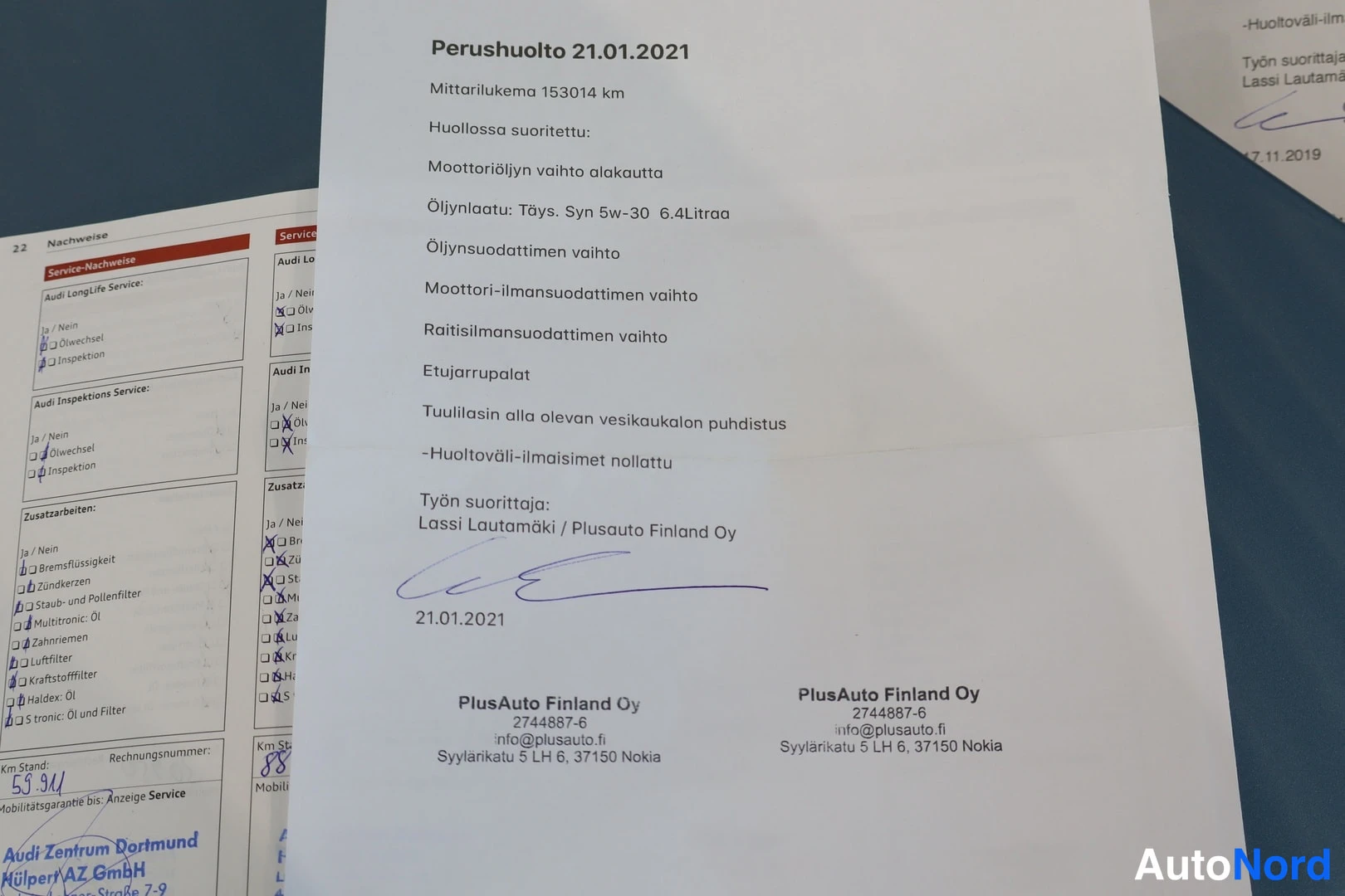 Yksityiskohta: Perushuoltotosite 21.01.2021 (PlusAuto Finland Oy), mittarilukema 153014 km, lueteltu suoritetut huoltotyöt, allekirjoitus Lassi Lautamäki.