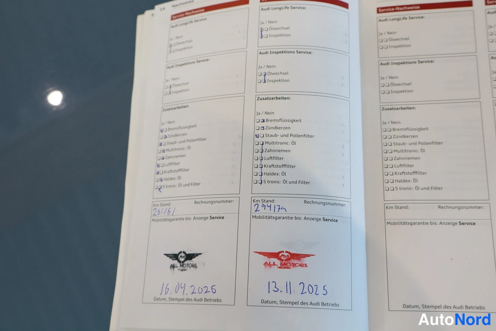 Muu: Audi-huoltokirjan aukeama, jossa huoltojen merkinnät: kilometrilukemat 28161(?) ja 29417n, ALL MOTORS -leimat ja päivämäärät 16.04.2025 ja 13.11.2025.