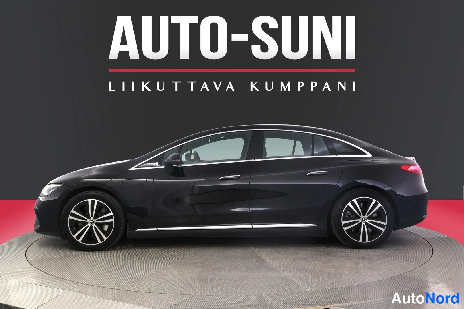 Sivulta: Mustan Mercedes-Benz EQE -sedanin profiili vasemmalta sivulta studiovalossa.