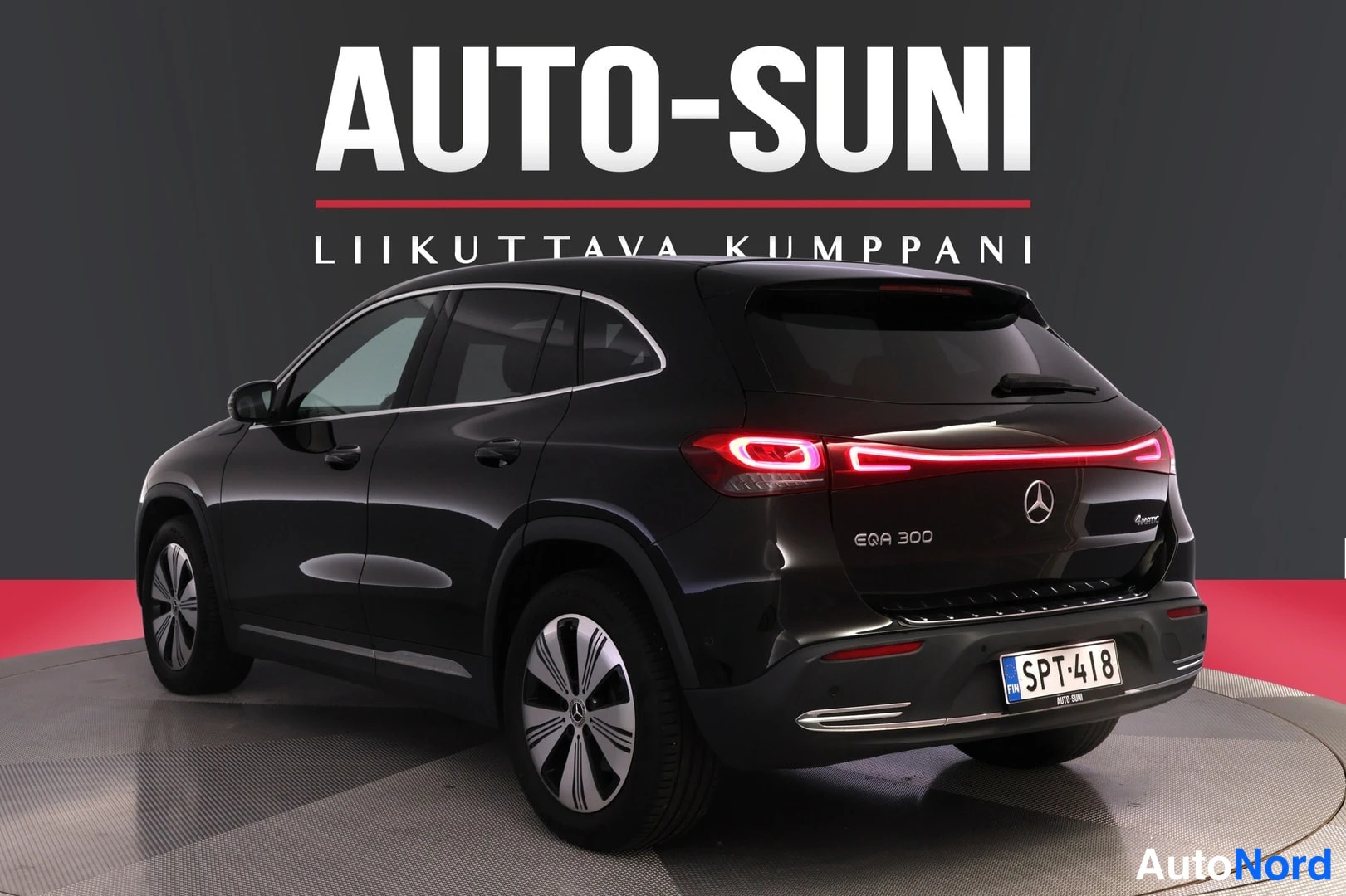 Takaviisto: Mustan Mercedes-Benz EQA:n takaosa ja vasen kylki kolmeneljäsosakulmasta; perävalot syttyneinä, rekisteri.