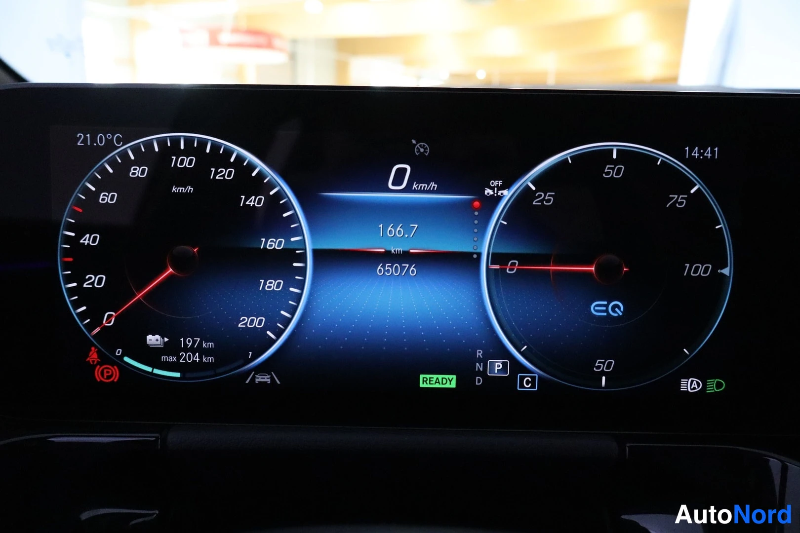 Yksityiskohta: Mercedes-Benz EQA:n digitaalinen mittaristo nopeusmittarilla ja EQ-merkinnällä, matka-anturi näyttää 65076 km.