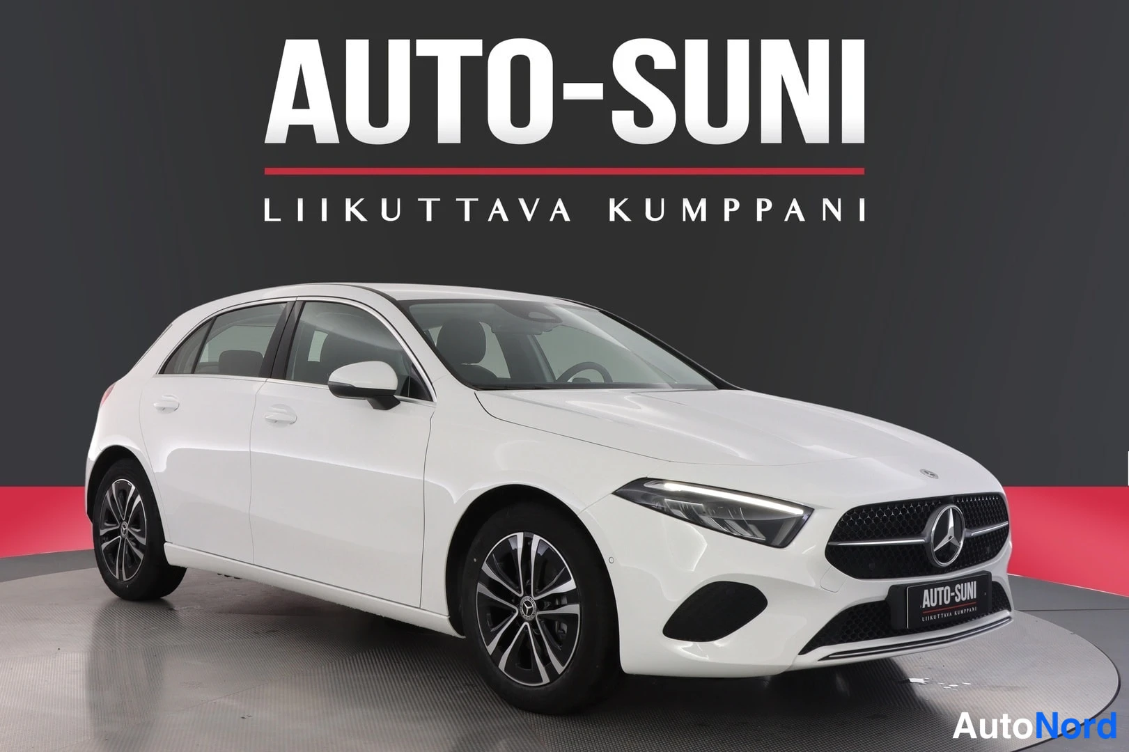 Etuviisto, nokka oikealle: Mercedes-Benz A -viistoperä valkoisena etuviistokuva oikealta, kromilattia ja tummat kevytmetallivanteet studioseenissä.