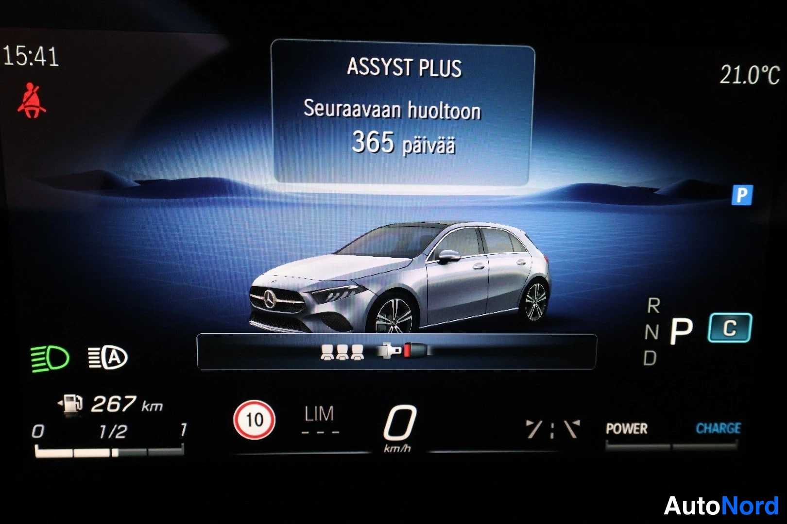 Muu: Kojelaudan näyttö: ASSYST PLUS -huoltoilmoitus 'Seuraavaan huoltoon 365 päivää', vaihde P, 21.0 °C.