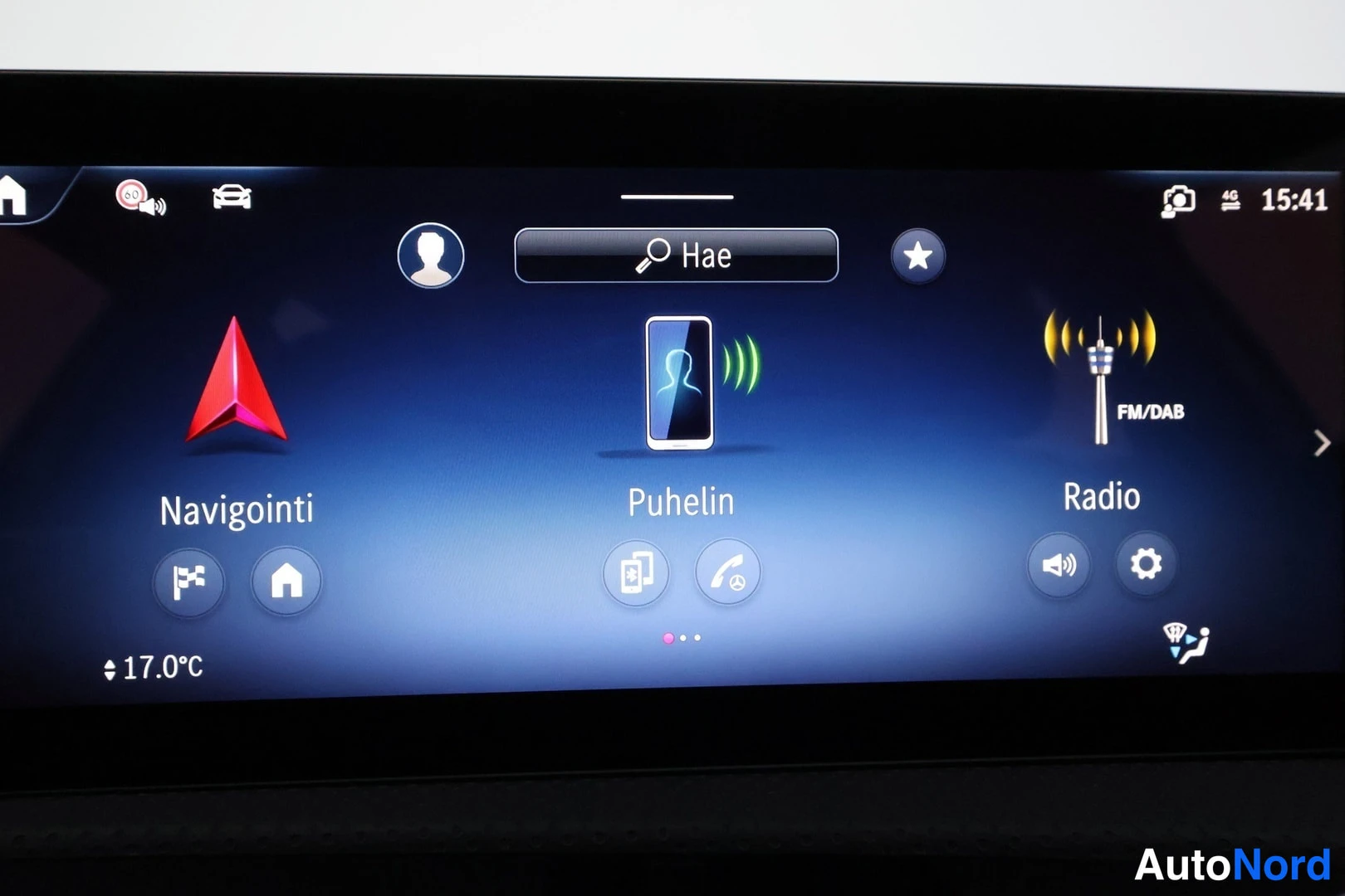 Muu: Infotainment-näytön päävalikko, jossa valinnat Navigointi, Puhelin ja Radio.