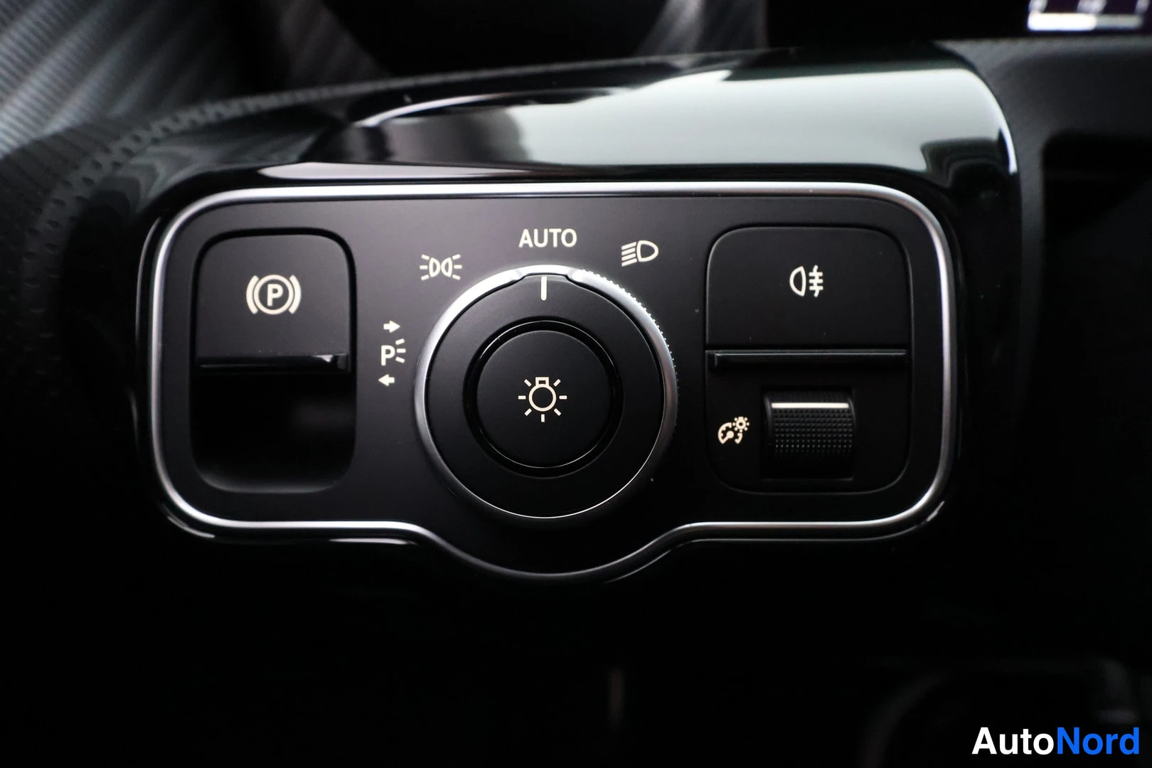 Muu: Valokytkinpaneeli lähikuvassa AUTO-merkinnällä, sumuvalojen painike ja ilmastointilaitteen säätöpyörä.
