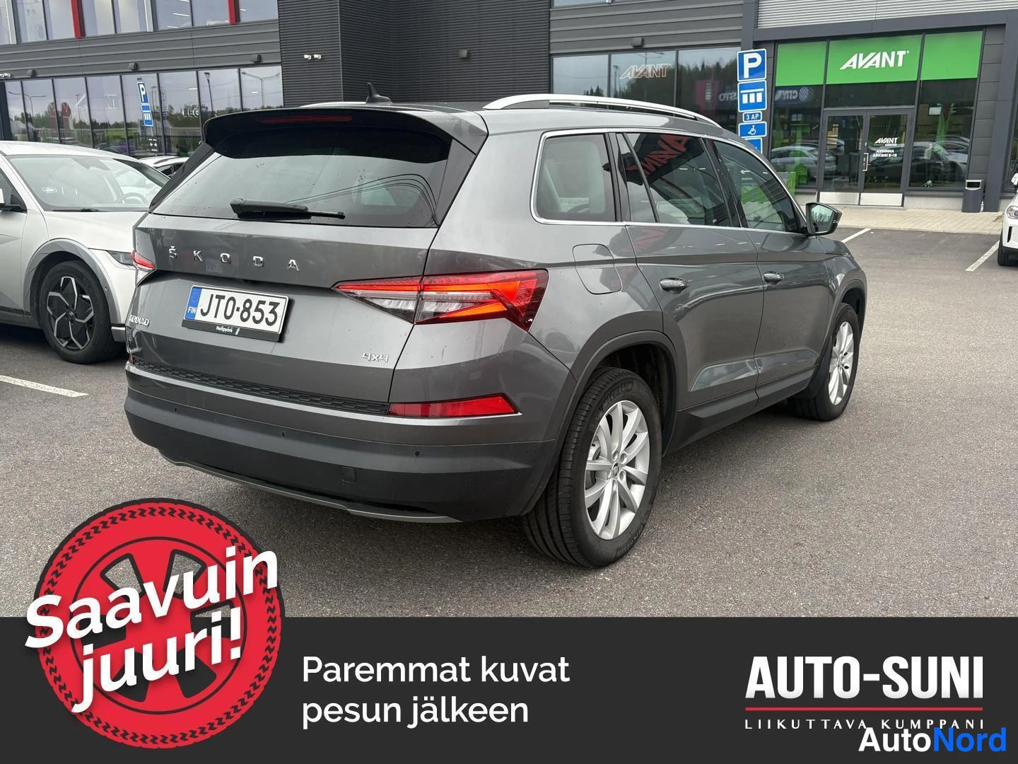 Takaviisto: Reikäkulmakuva harmaasta Skoda-kombista. Takana on '4x4'-merkki ja katolipatjat.