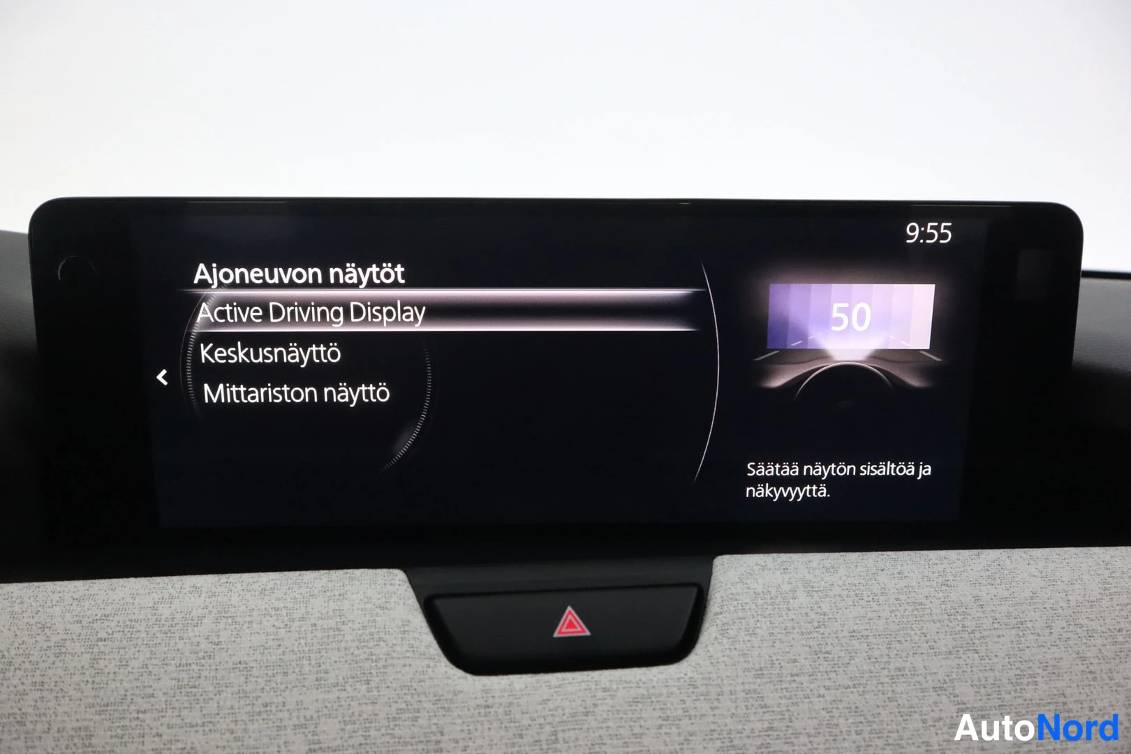Muu: Auton kojelaudan keskigallupn näyttö, jossa Ajoneuvon näytöt-valikko: Active Driving Display, Keskusnäyttö ja Mittariston näyttö; ajankohdan 9:55.