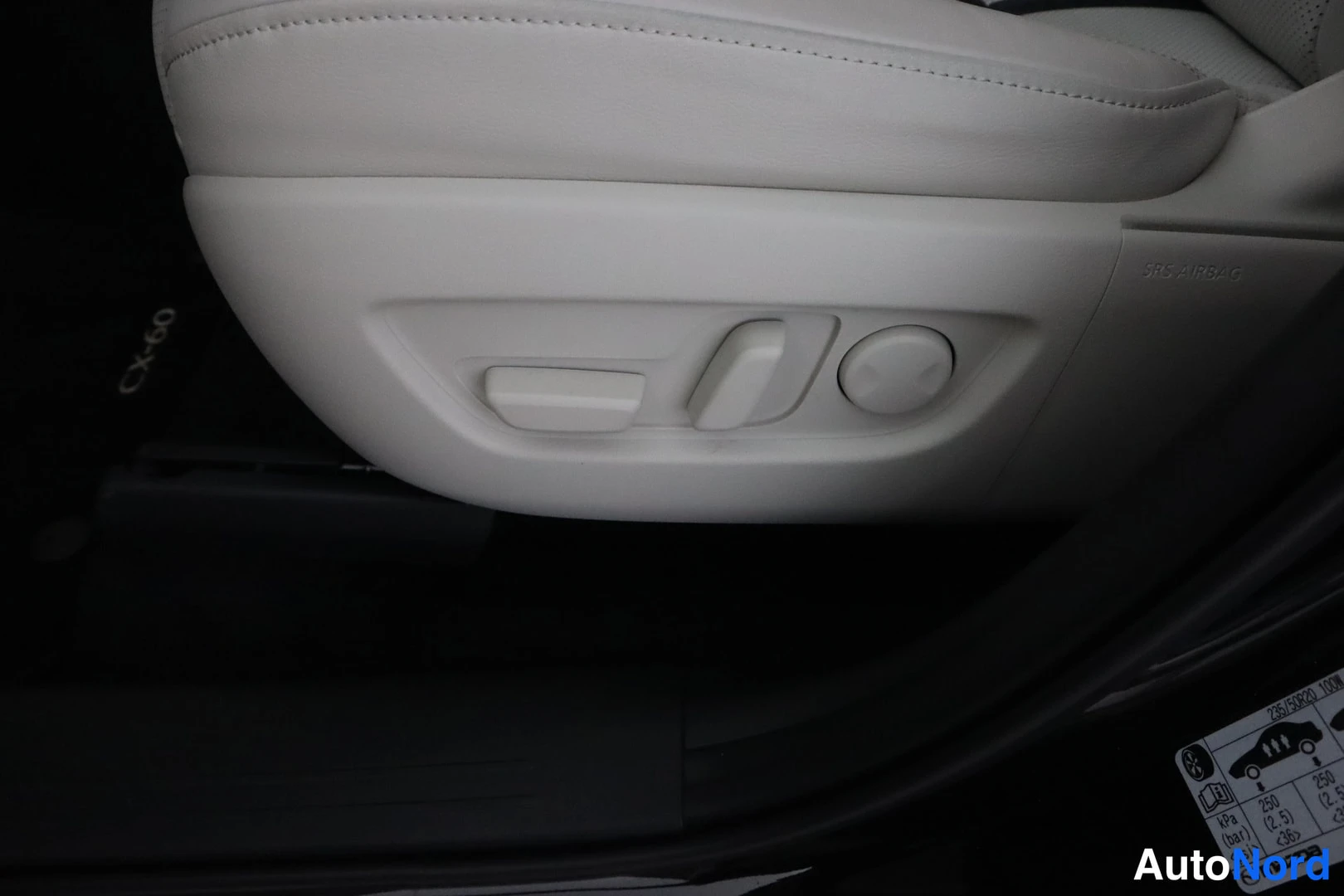 Muu: Etupenkin sivussa sähköistetyt istuimen säädöt ja SRS AIRBAG-teksti; ovempystyssä Mazda-renkaiden ilmanpaine -tarrat.
