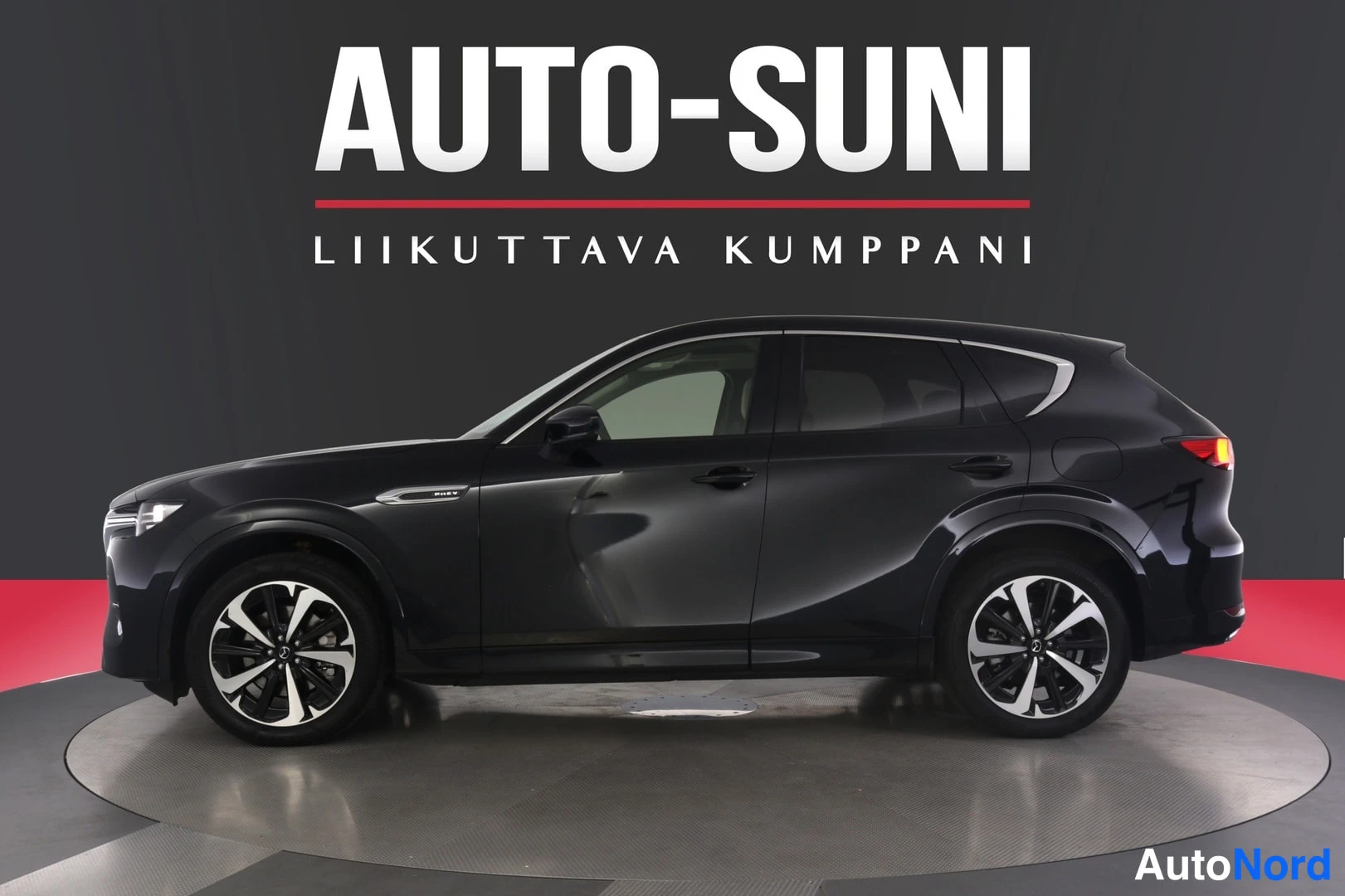 Sivulta: Mustan Mazda CX-60:n sivuprofiili studiotyttötaustaa vasten; vasen kylki, takavalot ja viisikeskeiset alumiinivanteet näkyvät.