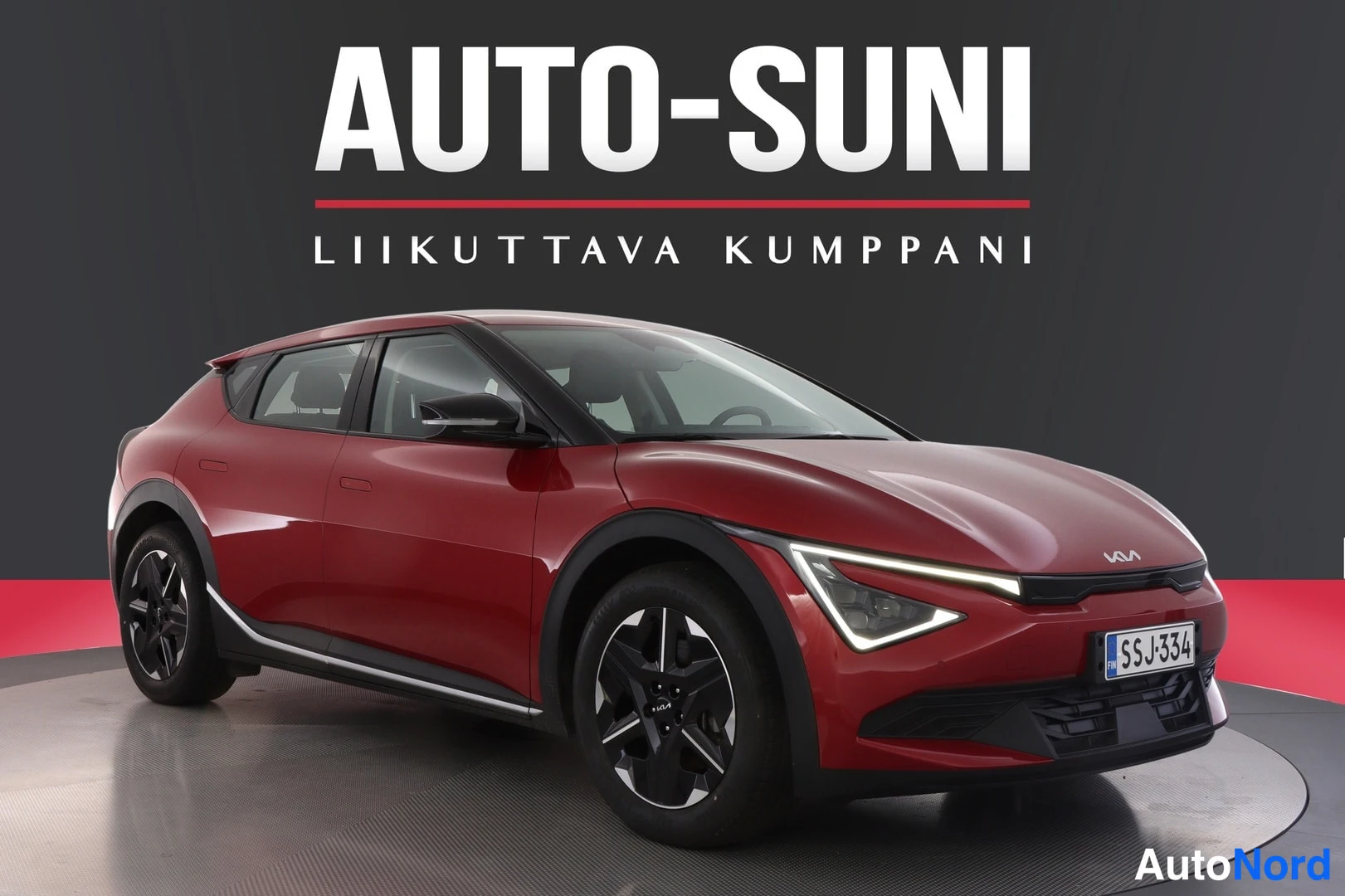 Etuviisto, nokka oikealle: Front three-quarter view of a red Kia hatchback with the nose pointing left