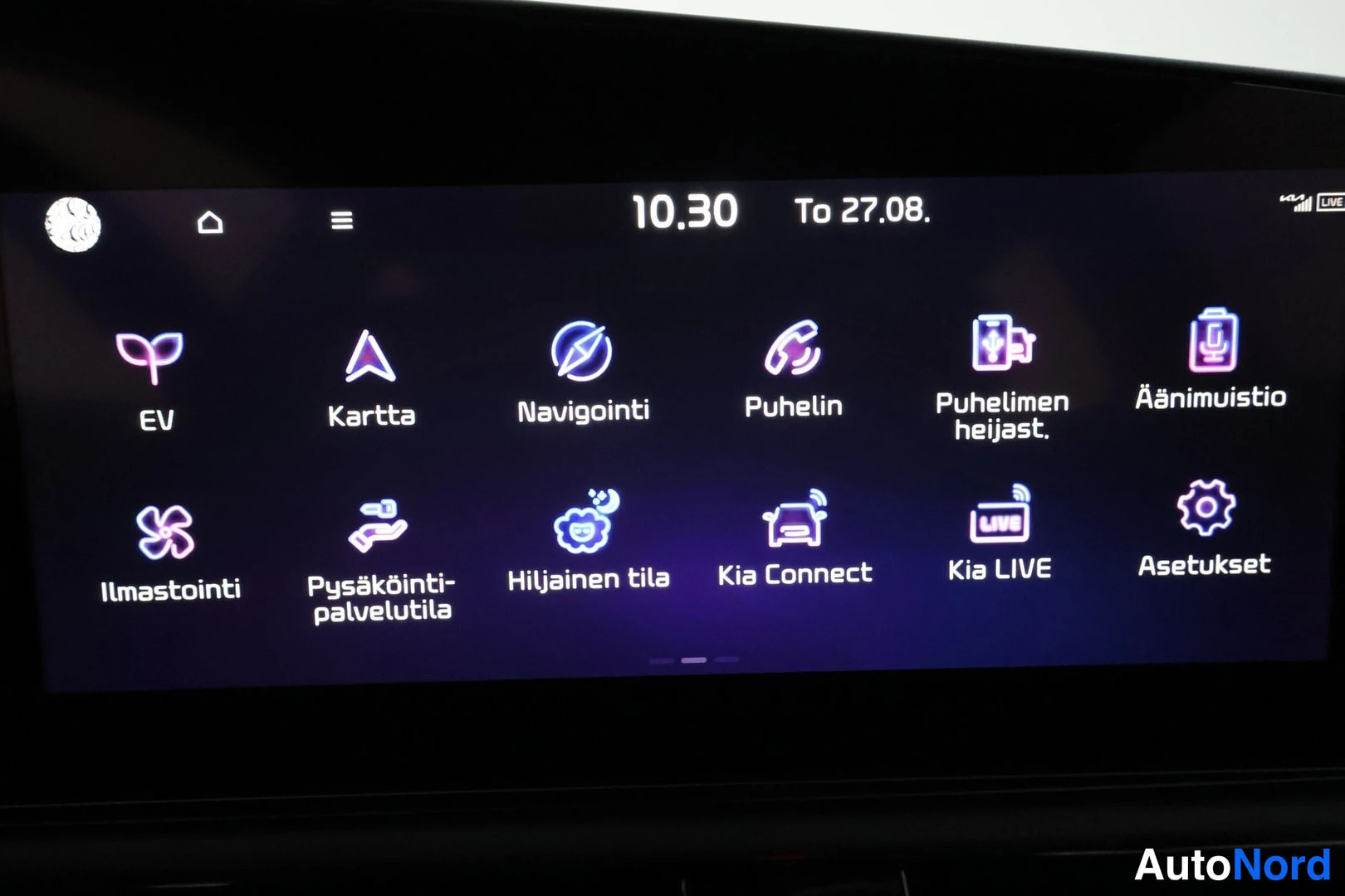 Ohjaamo: Close-up of the infotainment screen in Finnish. The icons shown are EV, Kartta (map), Navigointi (navigation), Puhelin (phone), Ilmastointi (air conditioning),