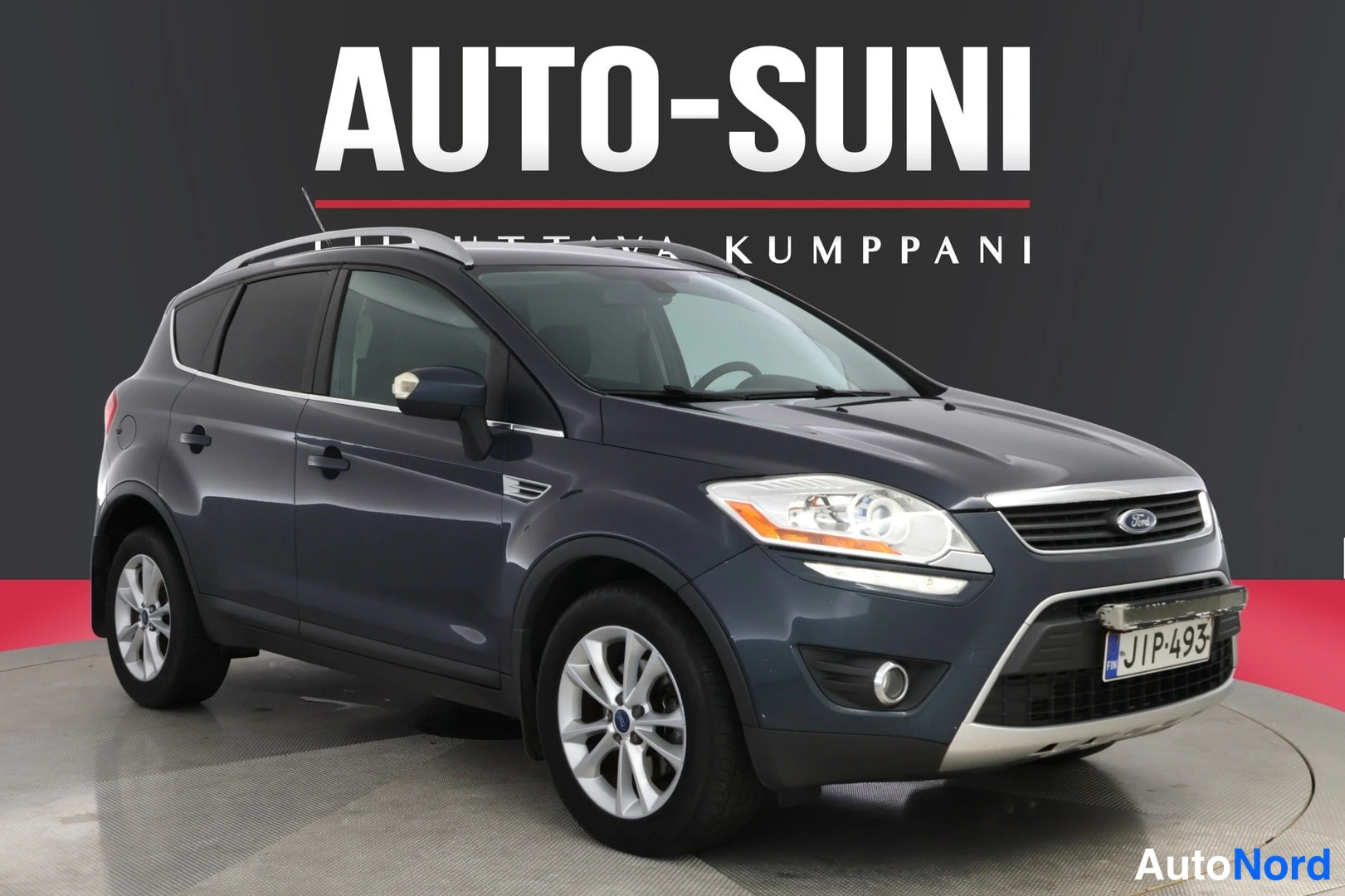 Etuviisto, nokka oikealle: Front view of a dark blue Ford Kuga with a white background.