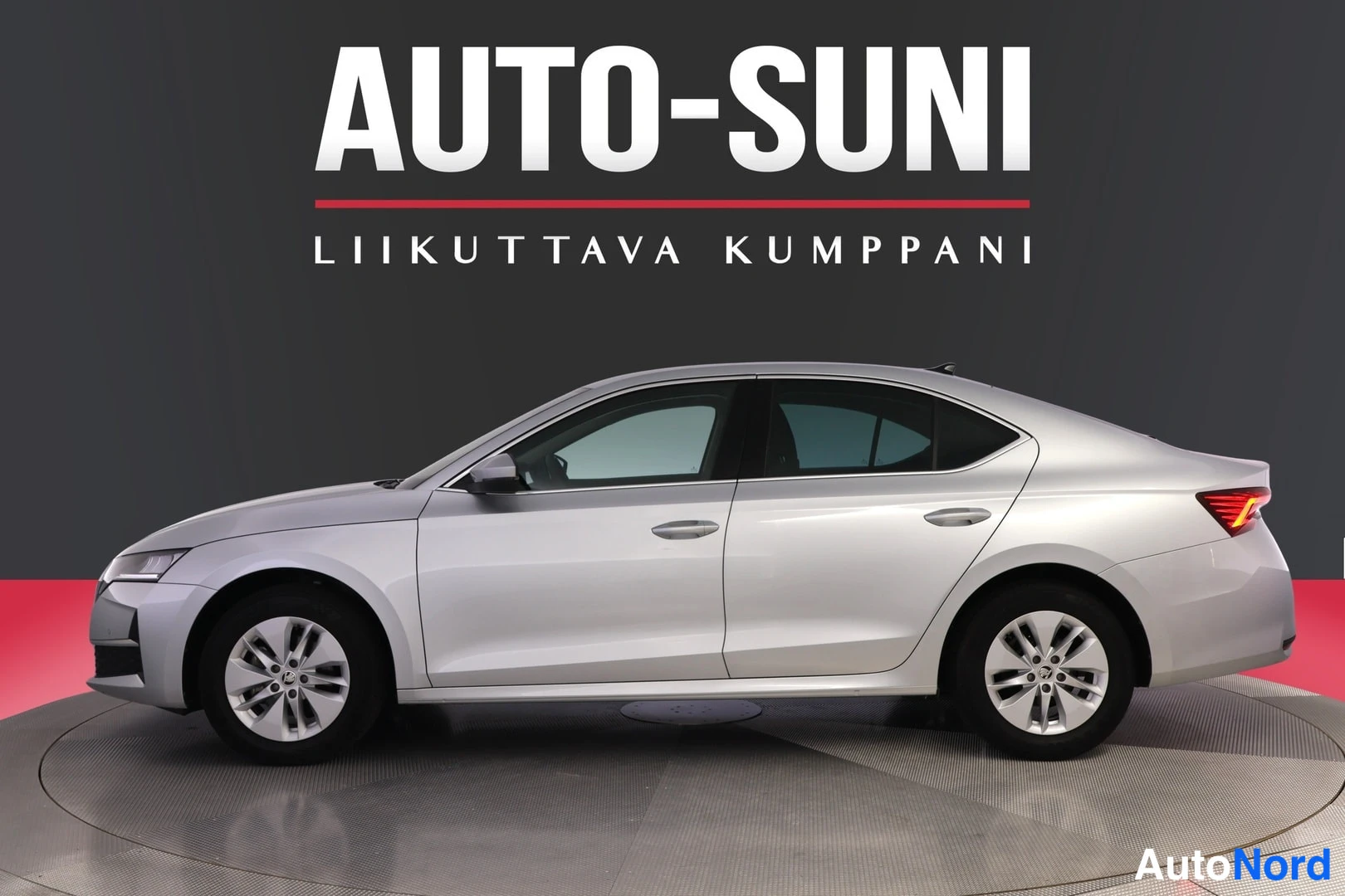 Sivulta: Silver sedan shown in side profile view with a dark grey wall and a red floor.