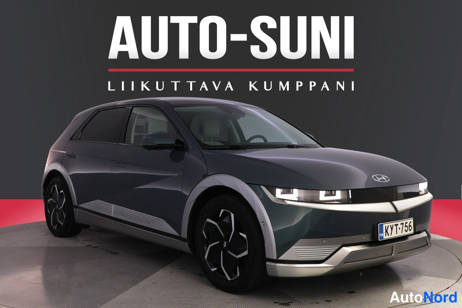 Etuviisto, nokka oikealle: Tummanharmaa Hyundai Ioniq 5 edestä kolmesta neljäsosasta: etuvalot, grili ja oikea kylki näkyvissä. Alumiivanteet renkaille, valkoiset LED-ajovalot.