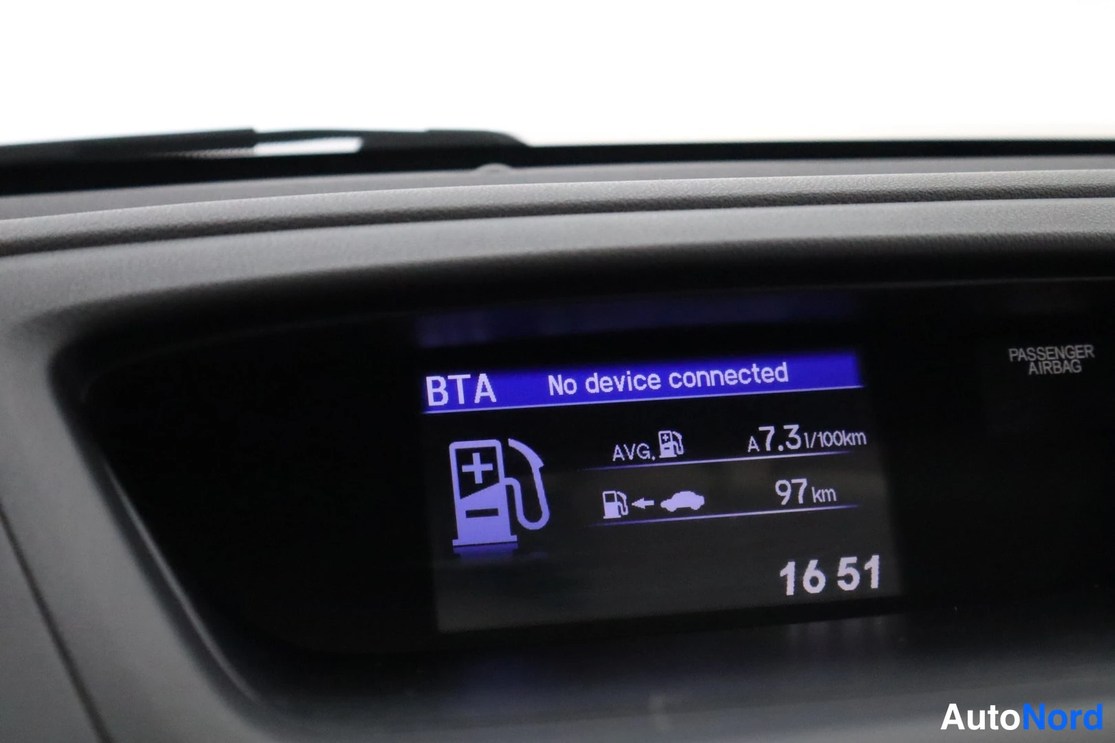 Yksityiskohta: Kojelaudan näyttö: BTA, No device connected, keskimääräinen kulutus A 7,3 l/100 km, jäljellä 97 km, kello 16 51.