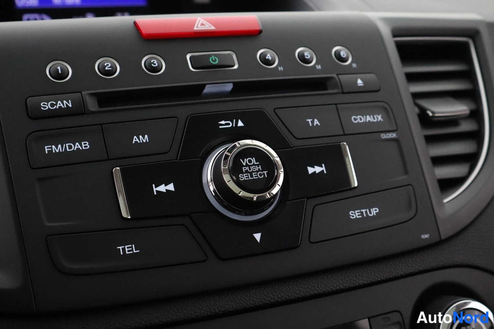 Yksityiskohta: Radion painikkeet: FM/DAB, AM, SCAN, TA, CD/AUX, TEL, SETUP ja VOL PUSH SELECT -keitto.