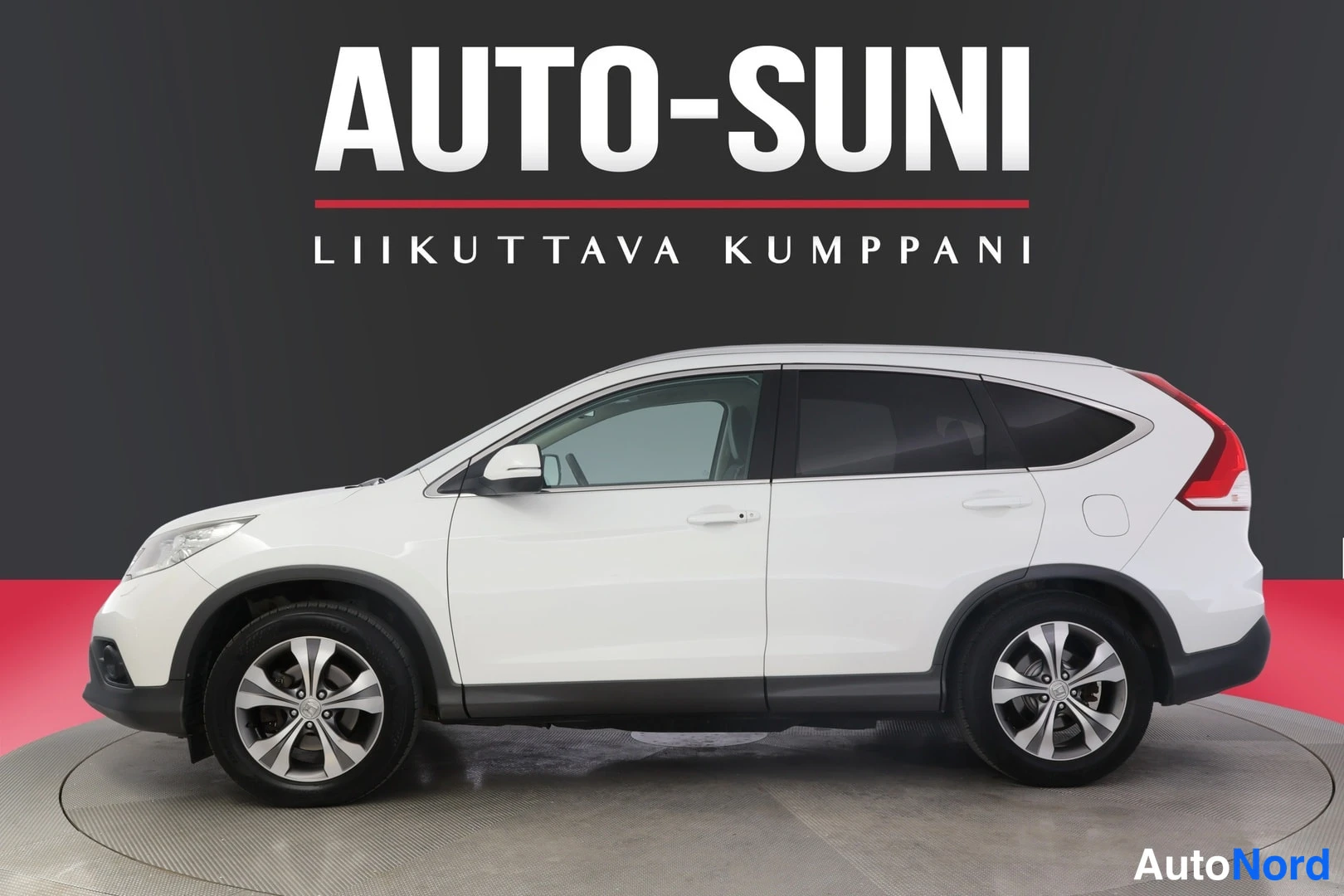 Sivulta: Valkoisen Honda CR-V:n vasen sivu ja etunurkka studio-ottelussa tummaa taustaa vasten.