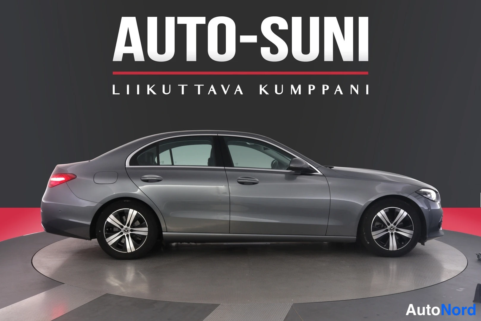 Etuviisto, nokka oikealle: Harmaan Mercedes-Benz C-sedan sivuprofiili, keula oikealla, Auto-Suni-studio.