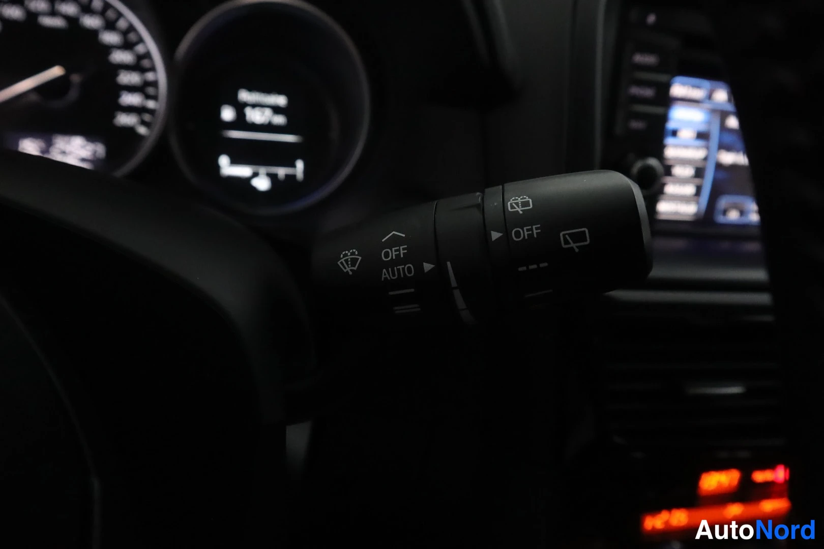 Muu: Sadejíristimen varsi AUTO- ja OFF-asemoilla, takana kojelaudan näyttö ja äänentoistolaitteen näyttö.