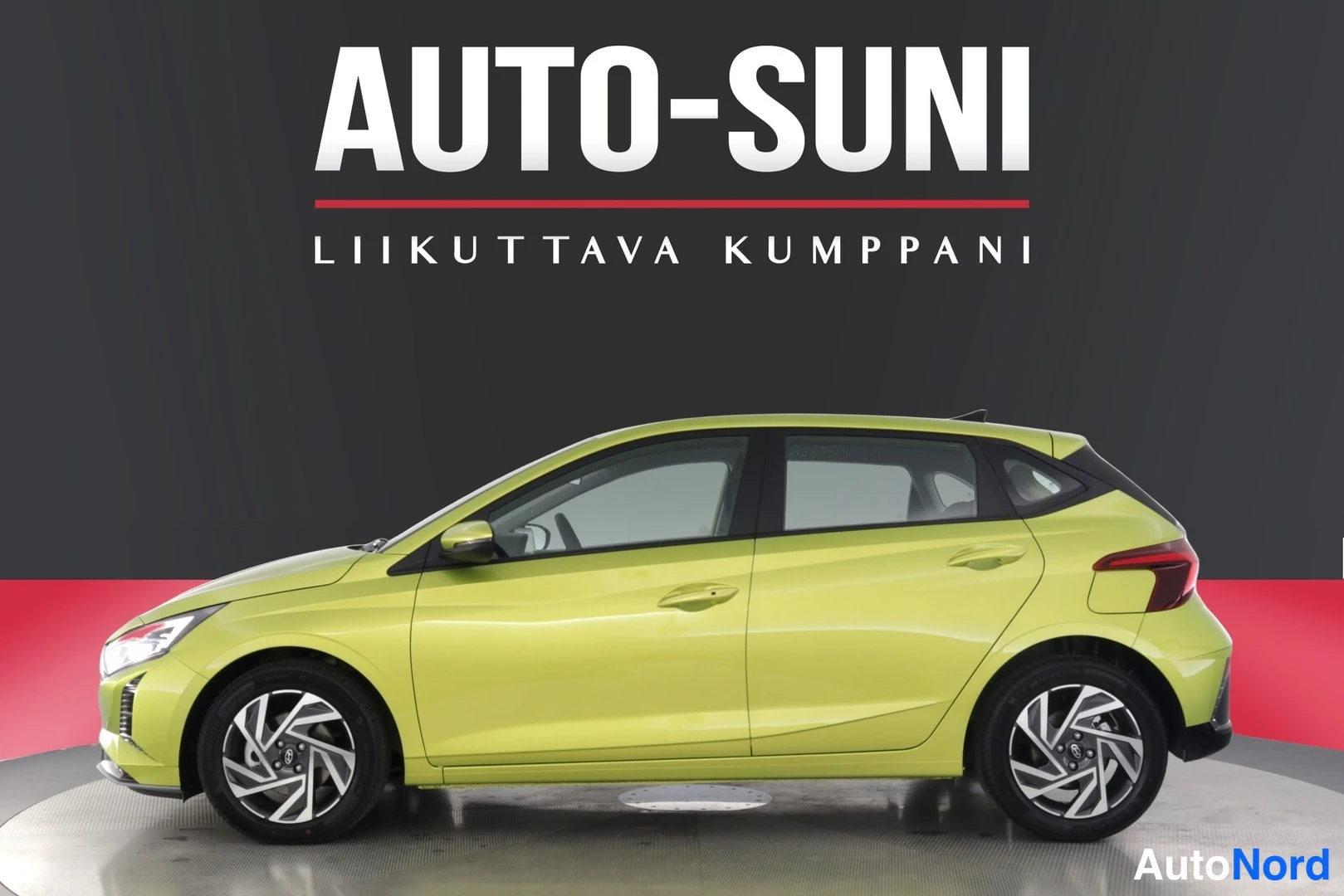 Sivulta: Keltavihreä Hyundai i20 -henkilöauto studiotaustaa vasten, Auto-Suni-logo kuvan yläosassa.