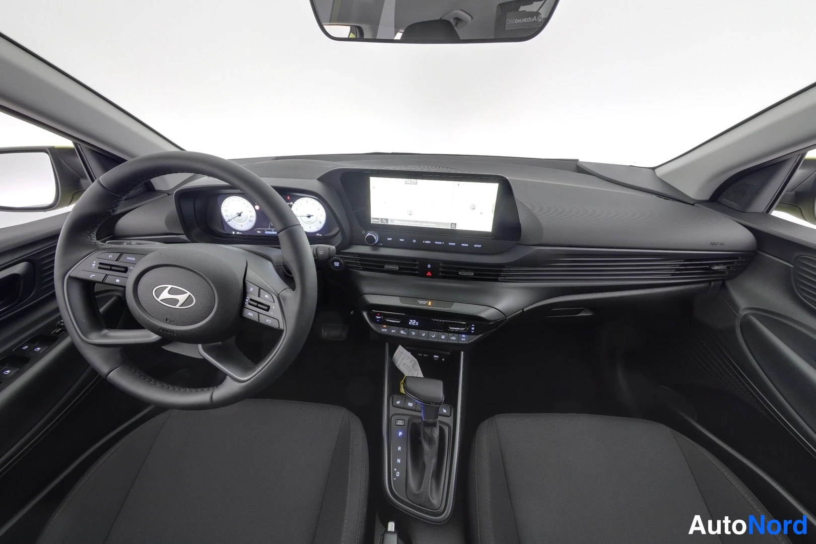Yksityiskohta: Hyundai i20:n ohjaamo ylhäältä: ratit, kojelauta ja kosketusnäyttö, musta sisusta.