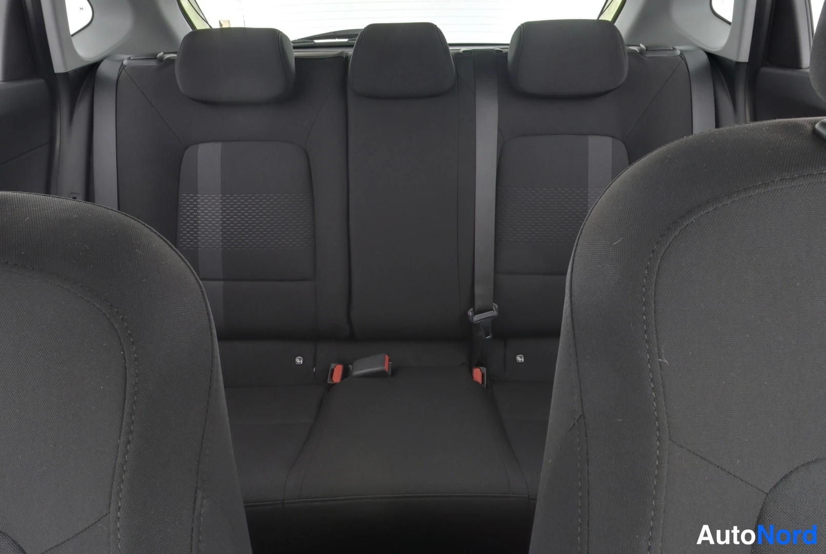 Yksityiskohta: Hyundai i20:n takapenkkikyykistys kolmella headrestillä, mustat kangasistuimet.