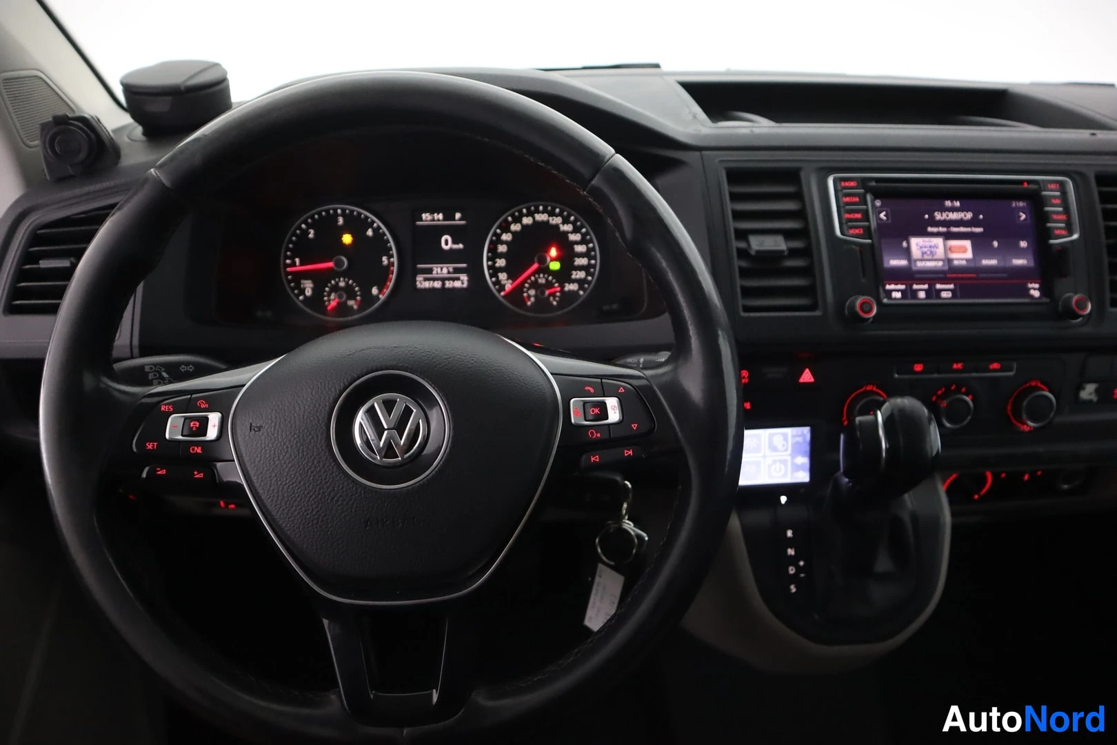 Muu: Ohjaamon näkymä: Volkwagen-ohjauspyörä, mittaristo, keskikonsolin infotainment-näyttö ja automaattivaihteiston valitsin.