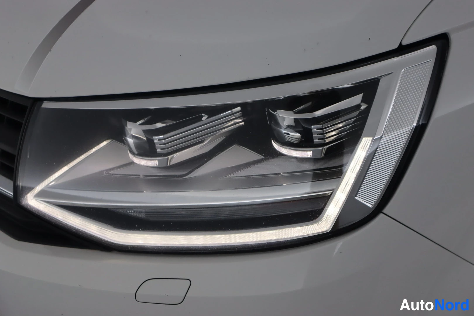 Edestä: Etuvaihto: valkoisen auton LED-etuvalo lähikuvassa, päiväajovalon piikkikuvio päällä.