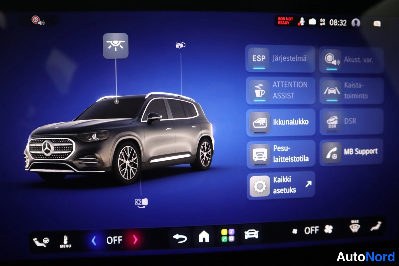 Muu: Mercedes-Benzin infotainment-näyttö, joka näyttää mustan SUV-auton ja suomenkielisen asetusvalikon: ESP, ATTENTION ASSIST, ikkunalukko, pesulaiteistotila, DSR j
