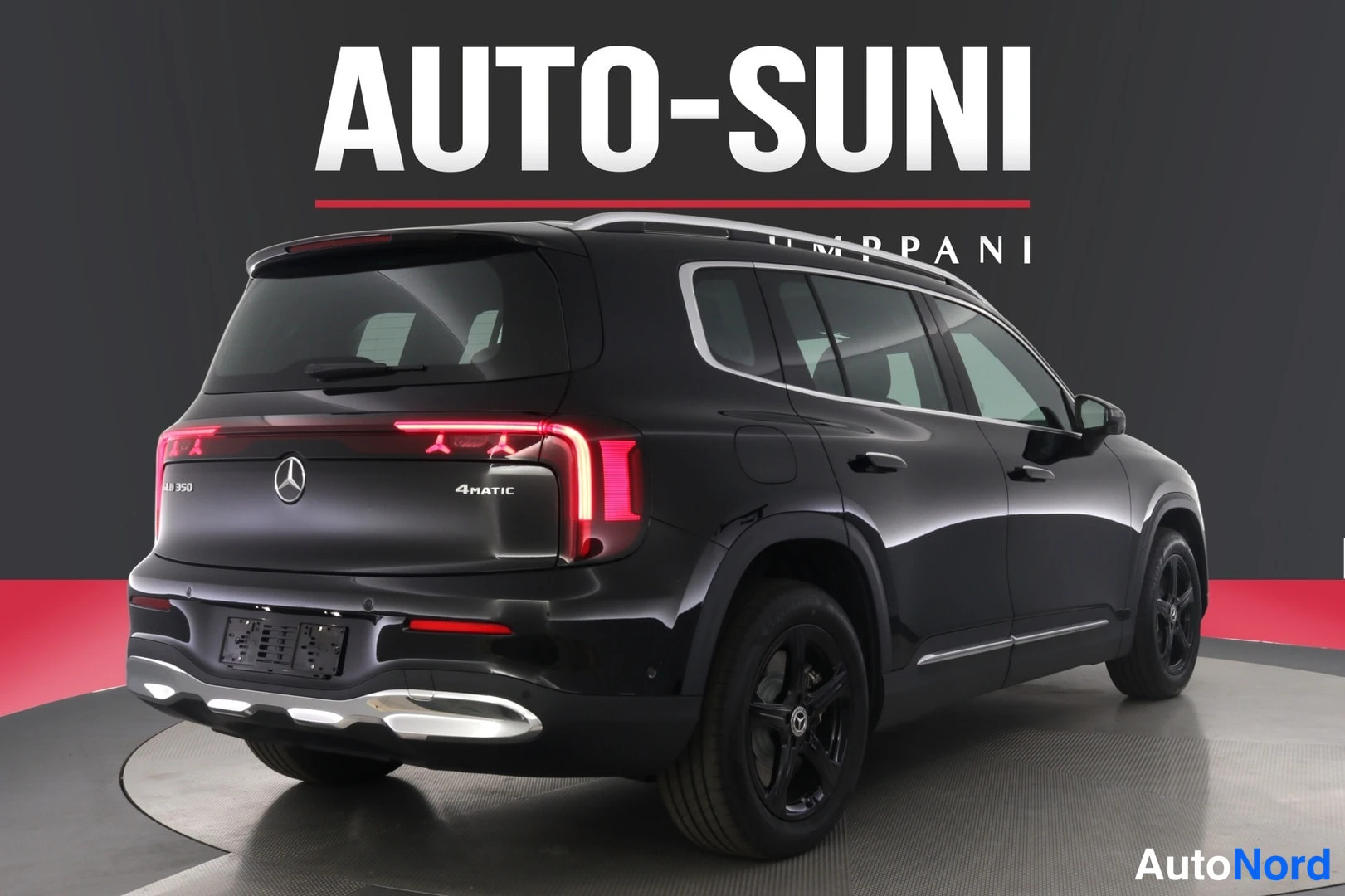 Takaviisto: Musta Mercedes-Benz GLB 350 4MATIC takaviistöltä vasemmalta, punaiset takavalot ja keulaspoileri näkyvissä, mustat pyörät.