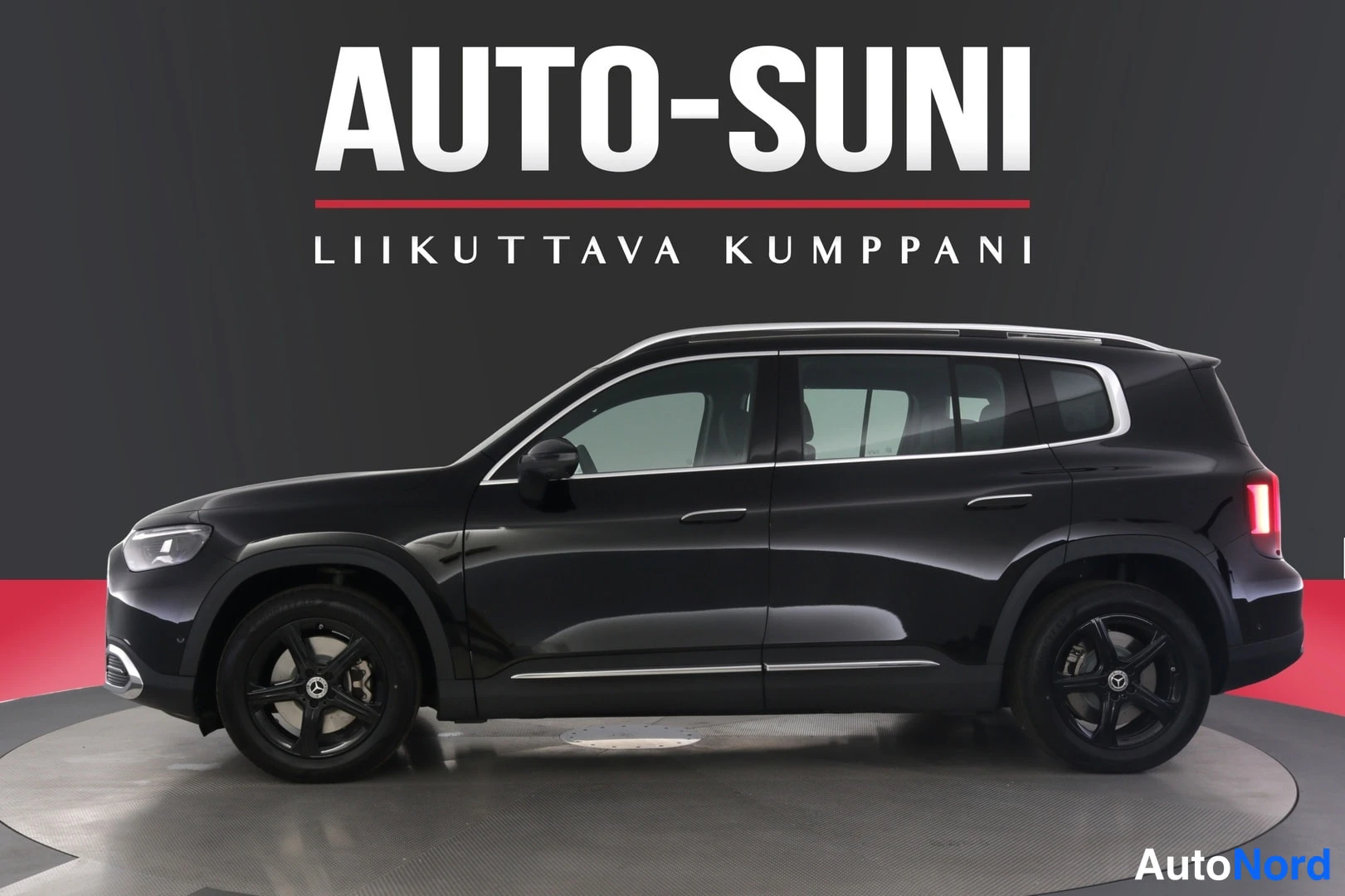 Sivulta: Mustan Mercedes-Benz GLB -maasturin sivuprofiili studiotaululla, kauppiaan AUTO-SUNI-logo taustalla.