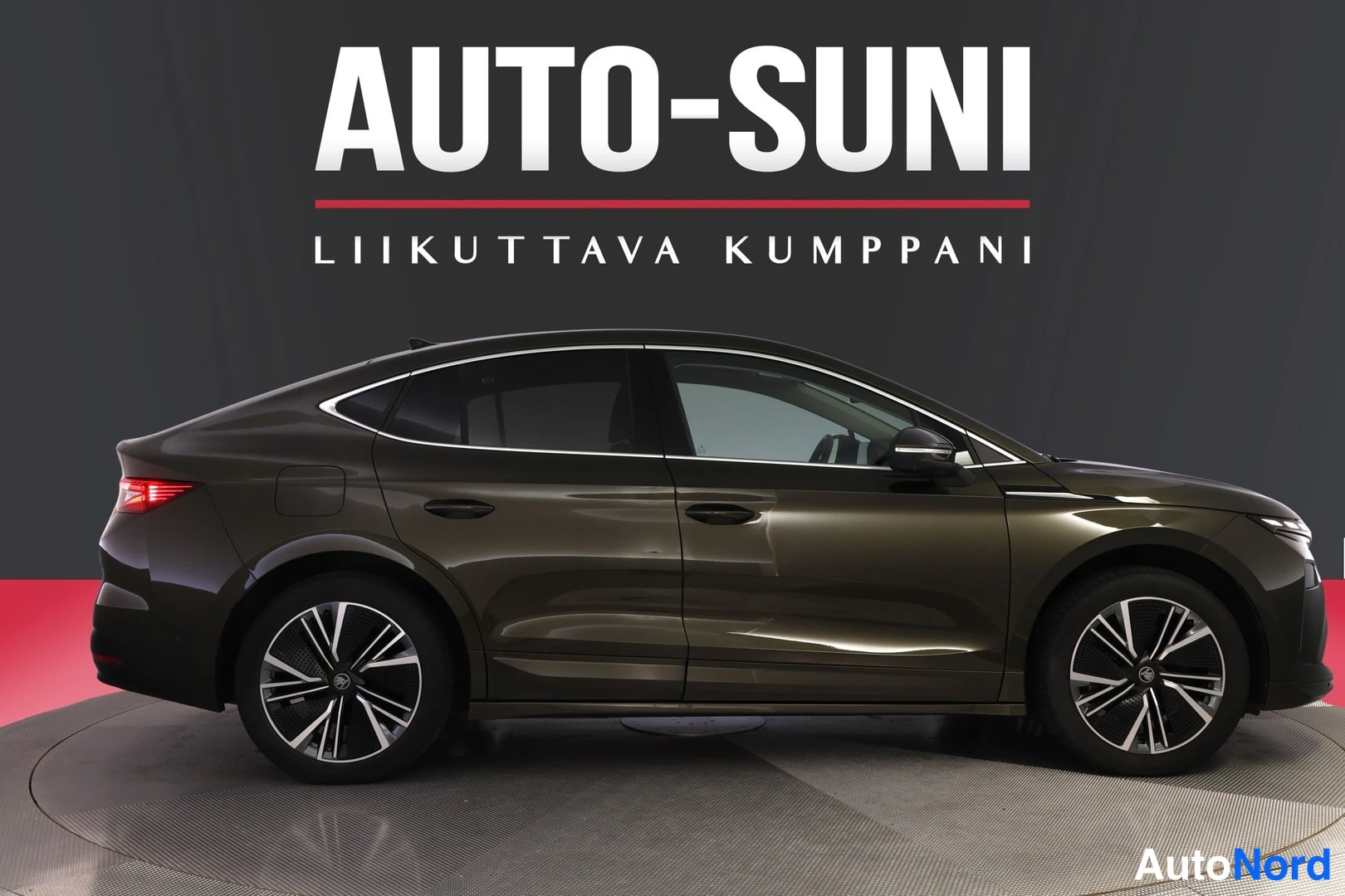 Etuviisto, nokka oikealle: Skoda Enyaq Coupé sivukulmasta kuvattuna, tummanruskea kori, keulan kärki näkyy oikealla reunassa.