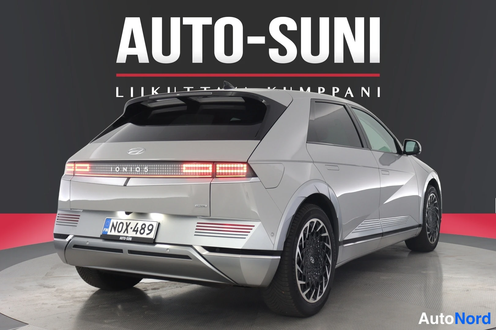 Takaa: Rear view of the vehicle on a showroom turntable.