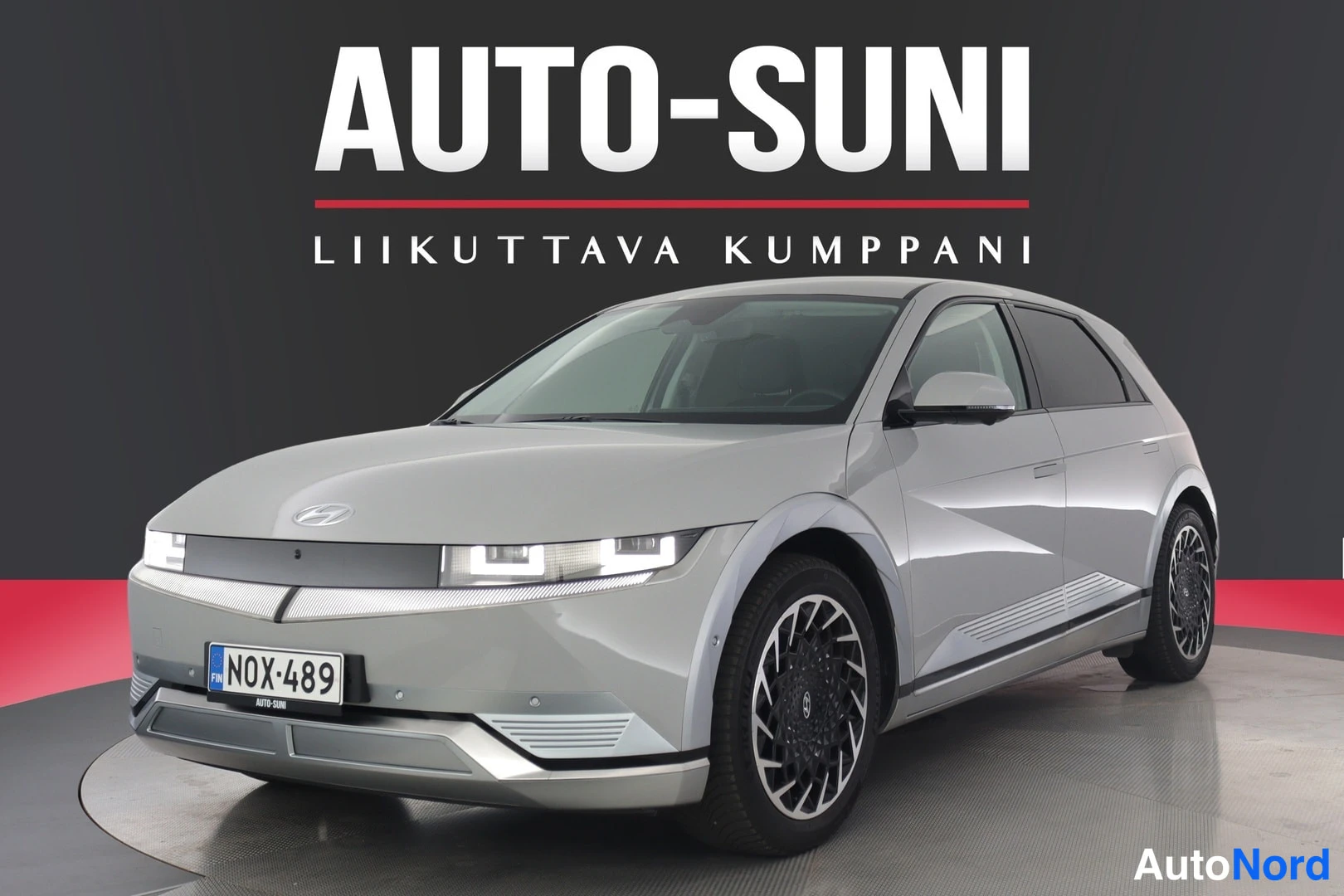 Etuviisto, nokka vasemmalle: Hopeanvärinen Hyundai IONIQ 5 suoraan edestäpäin kuvattuna; näkyvät harmaan puskurin, ajovalot ja rekisterikilpi.