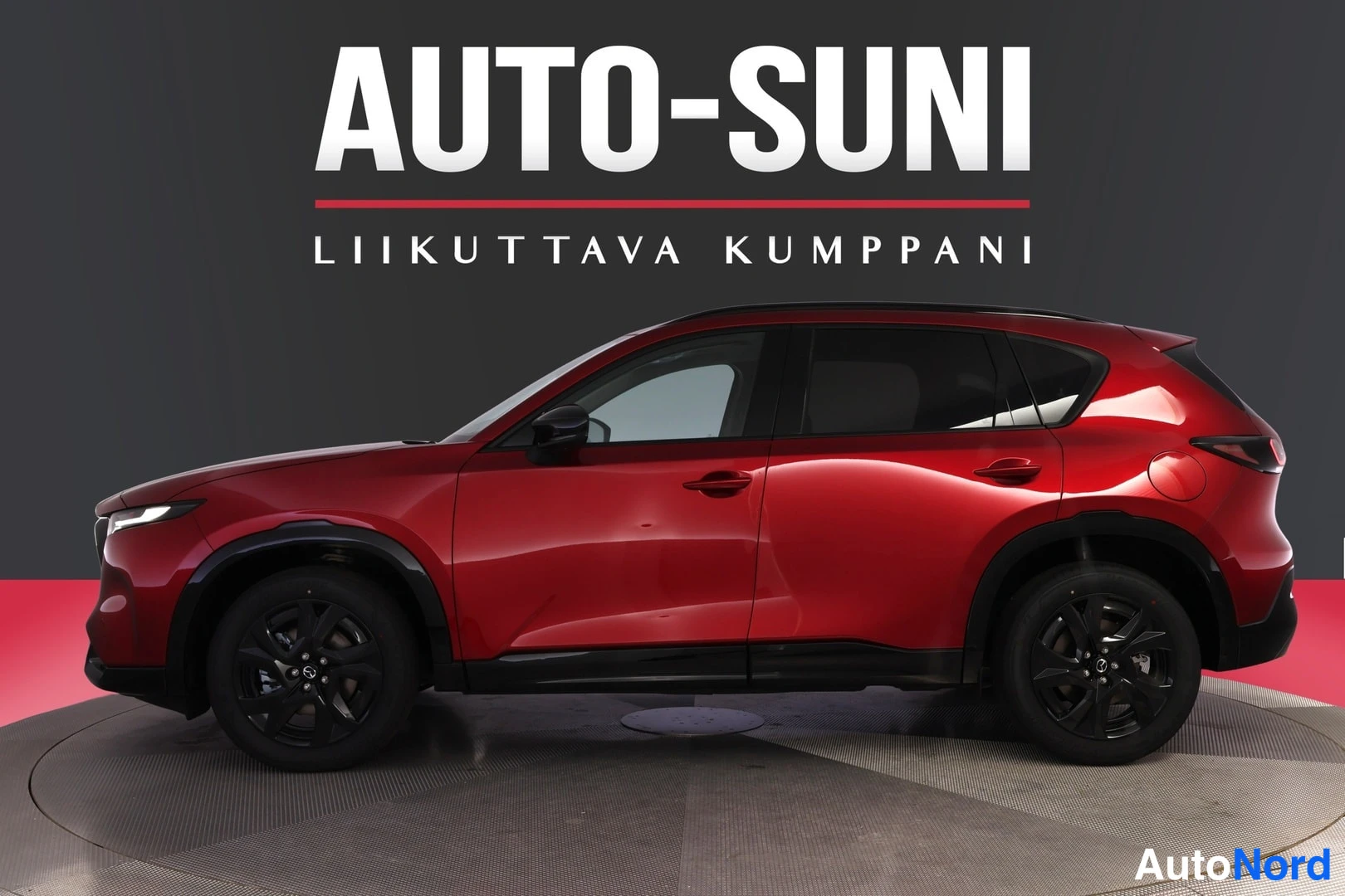 Sivulta: Sivukuvanäkökulma punaisesta Mazda CX-5 -maasturista valkoisella AUTO-SUNI -logolla taustalla.