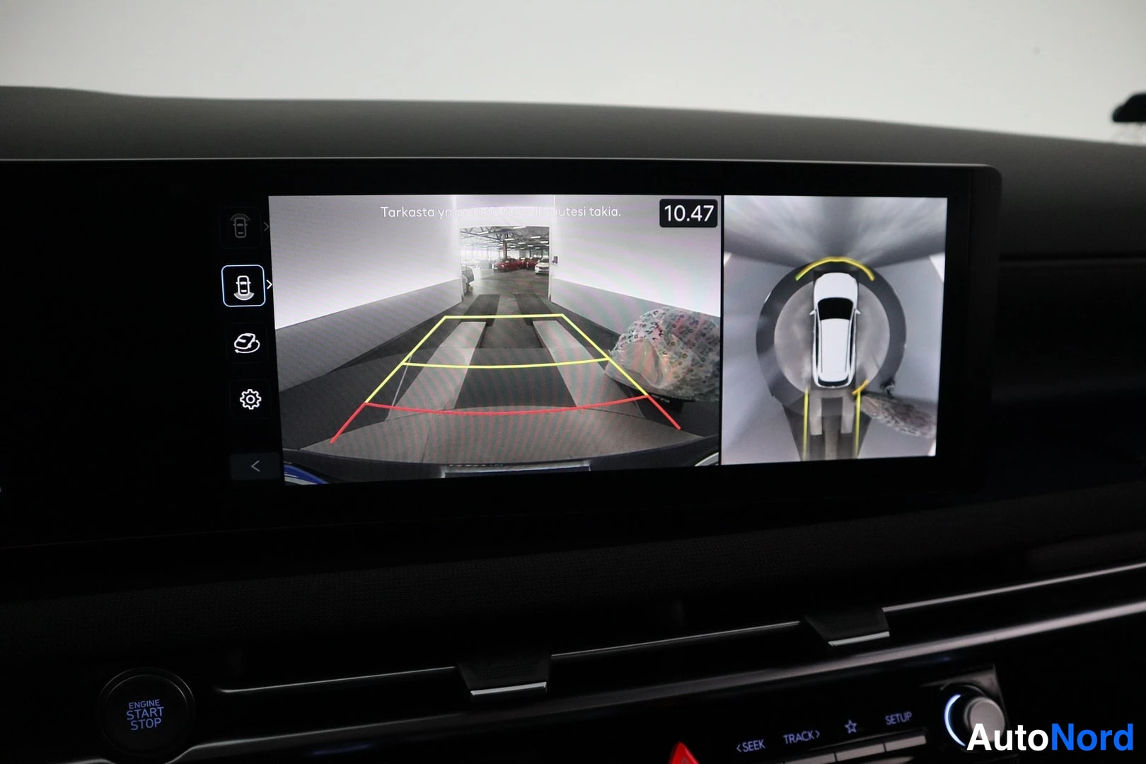 Muu: Infotainment-näytöllä kamera-avusteinen peruutustilanäkymä ympäröivän kameran kuvalla ja ikonivalikolla.