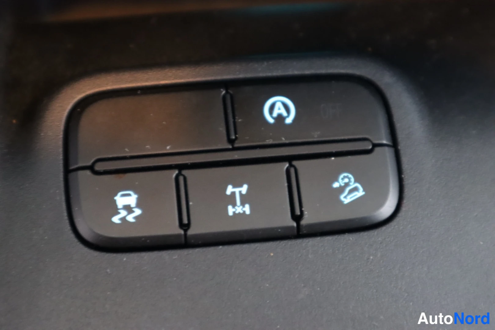 Yksityiskohta: Kojelaudan painikeryhmä: auto start/stop-, mäkijarru-, vetoluisto- ja vakionopeudensäädin/katetun auton painikkeet.