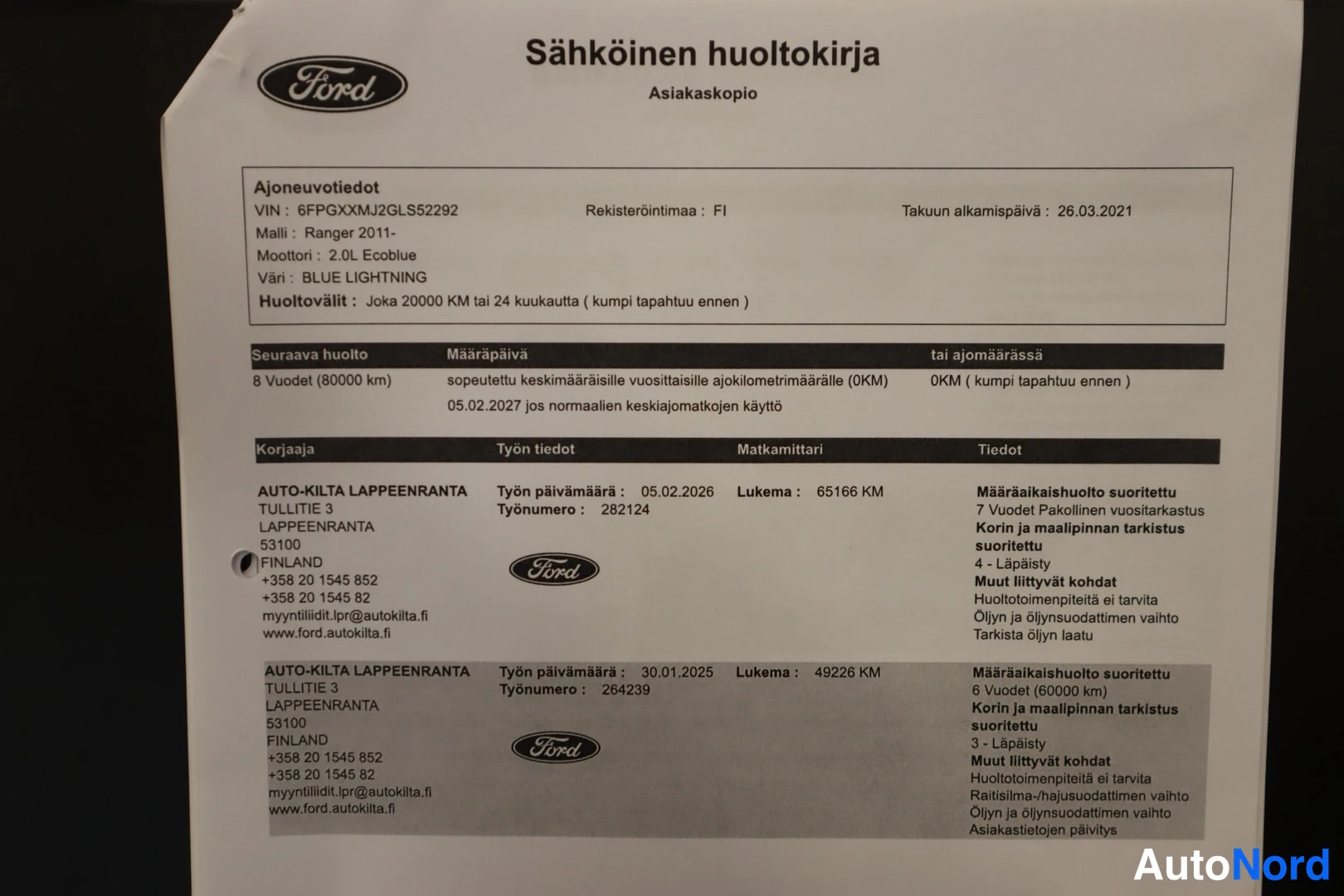 Yksityiskohta: Ford-merkin sisältävä painettu huoltokirjan asiakaskopio, jossa ajoneuvotiedot ja kaksi huoltomerkintää.