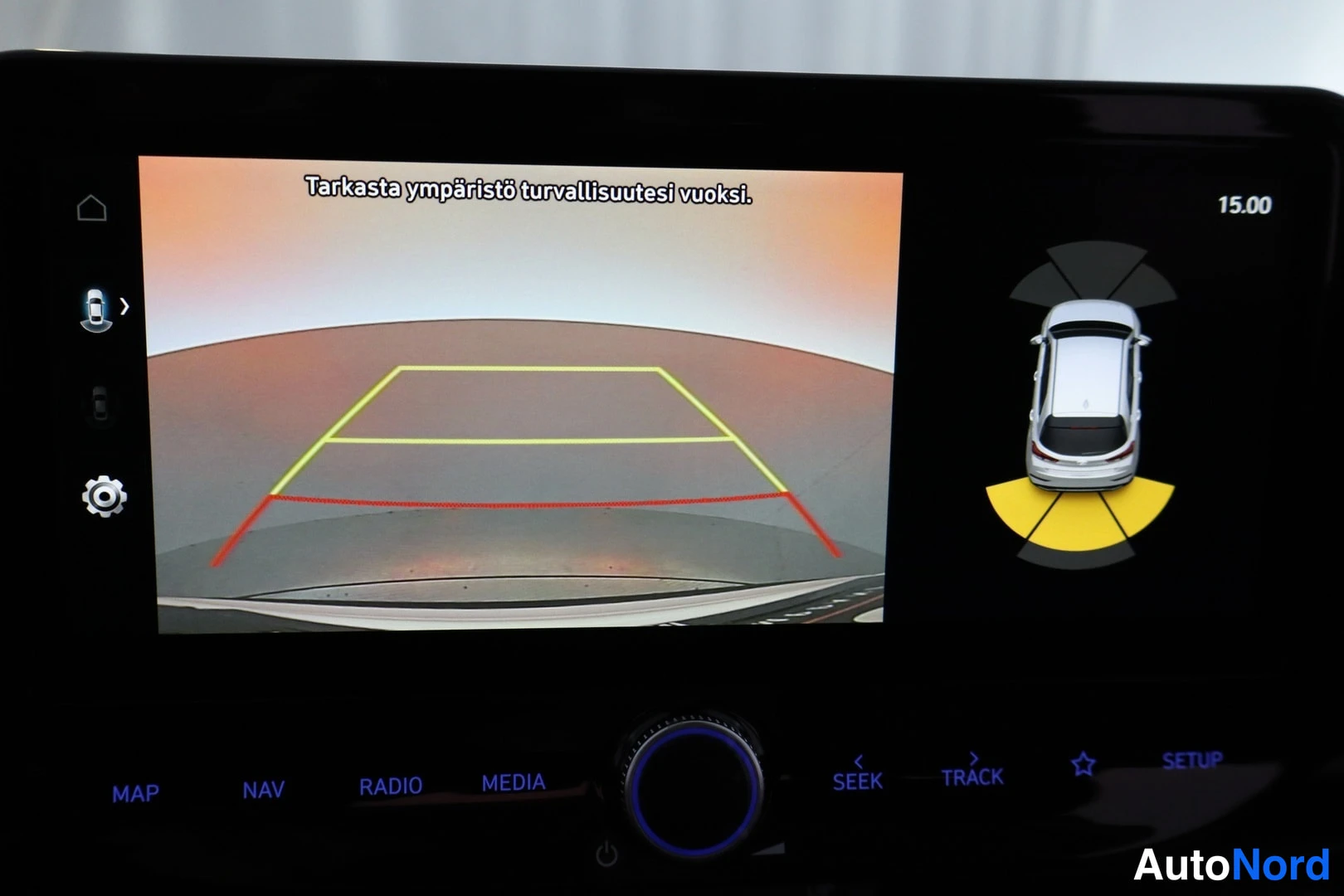 Muu: Infotainment-näyttö näyttää peruutuskamerakuvaa varoituksella Tarkasta ympäristö turvallisuutesi vuoksi, ohjausviivoineen ja ympäriview-simulaatiolla autosta.