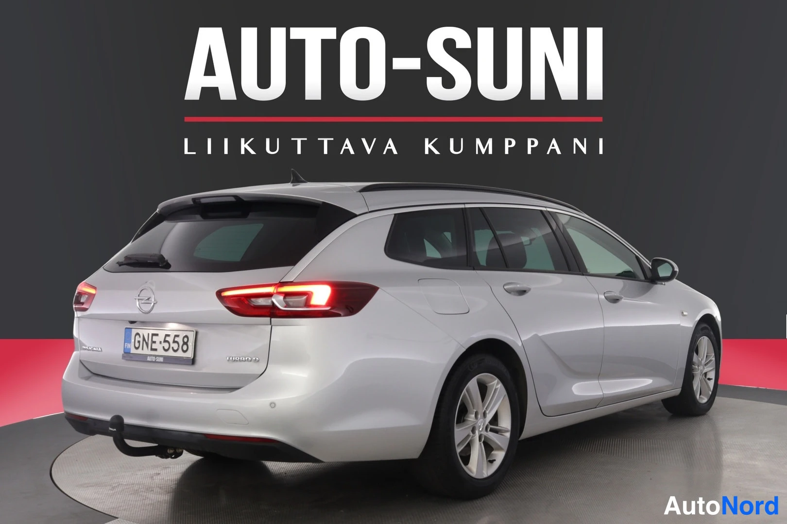 Takaviisto: Hopeanvärinen farmariauto takaa vasemmalta kuvattuna, takavalo litistetty, rekisterikilpi