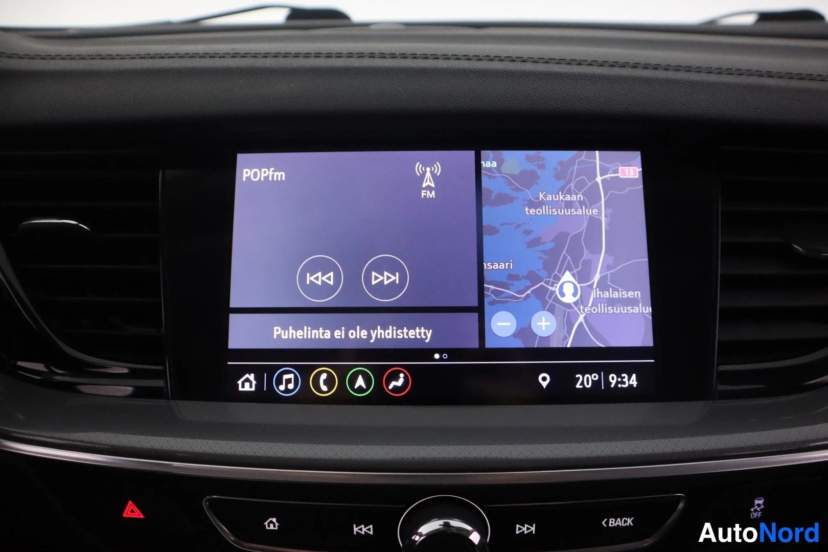 Muu: Kojelaudan infotainment-näyttö radiolla, karttanäkymällä ja viestillä 'Puhelinta ei ole yhdistetty'.