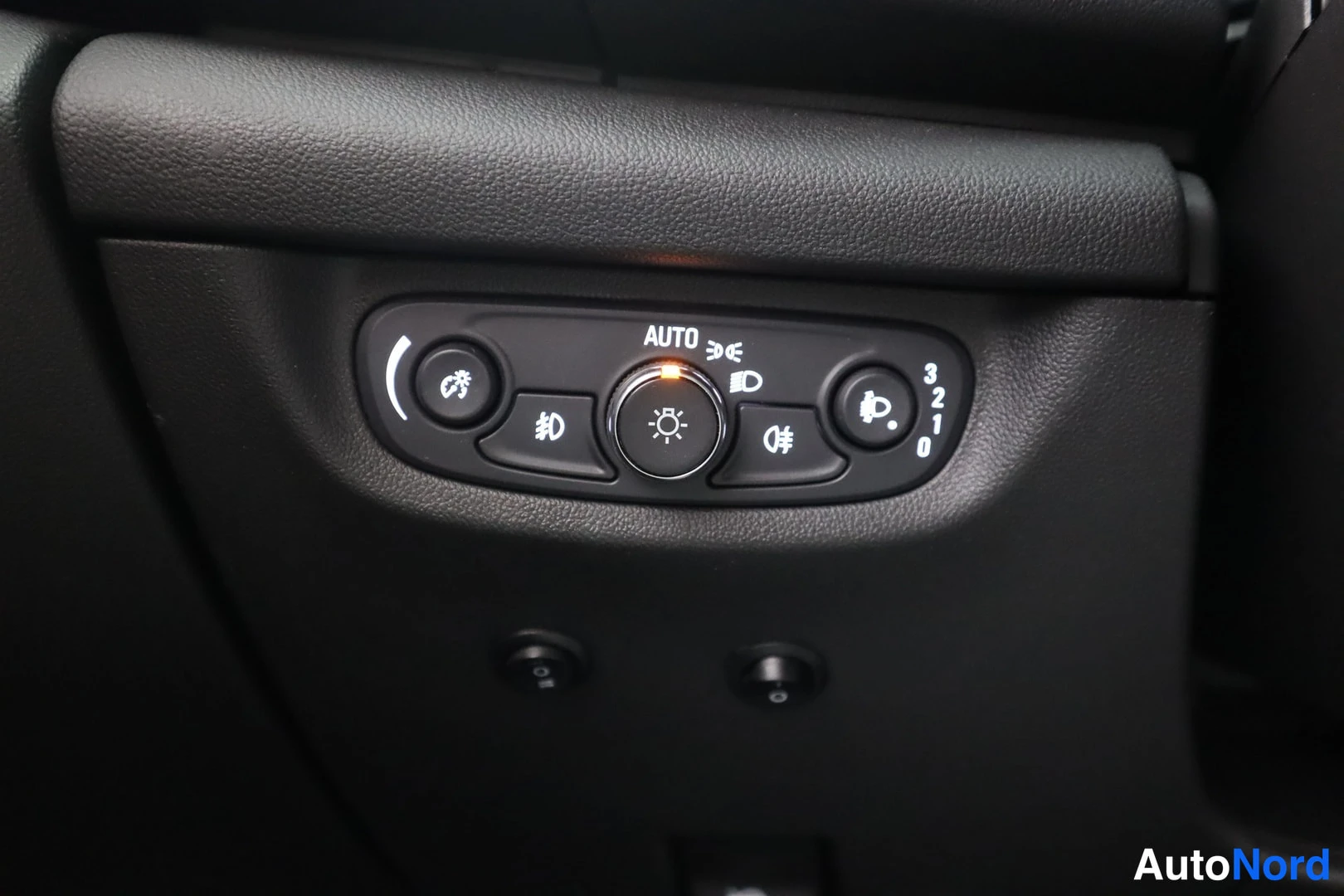 Muu: Sisäkuva auton valojen hallintakytkimistÃ¤, jossa AUTO-teksti ja valaistussÃ¤Ã¤timet.