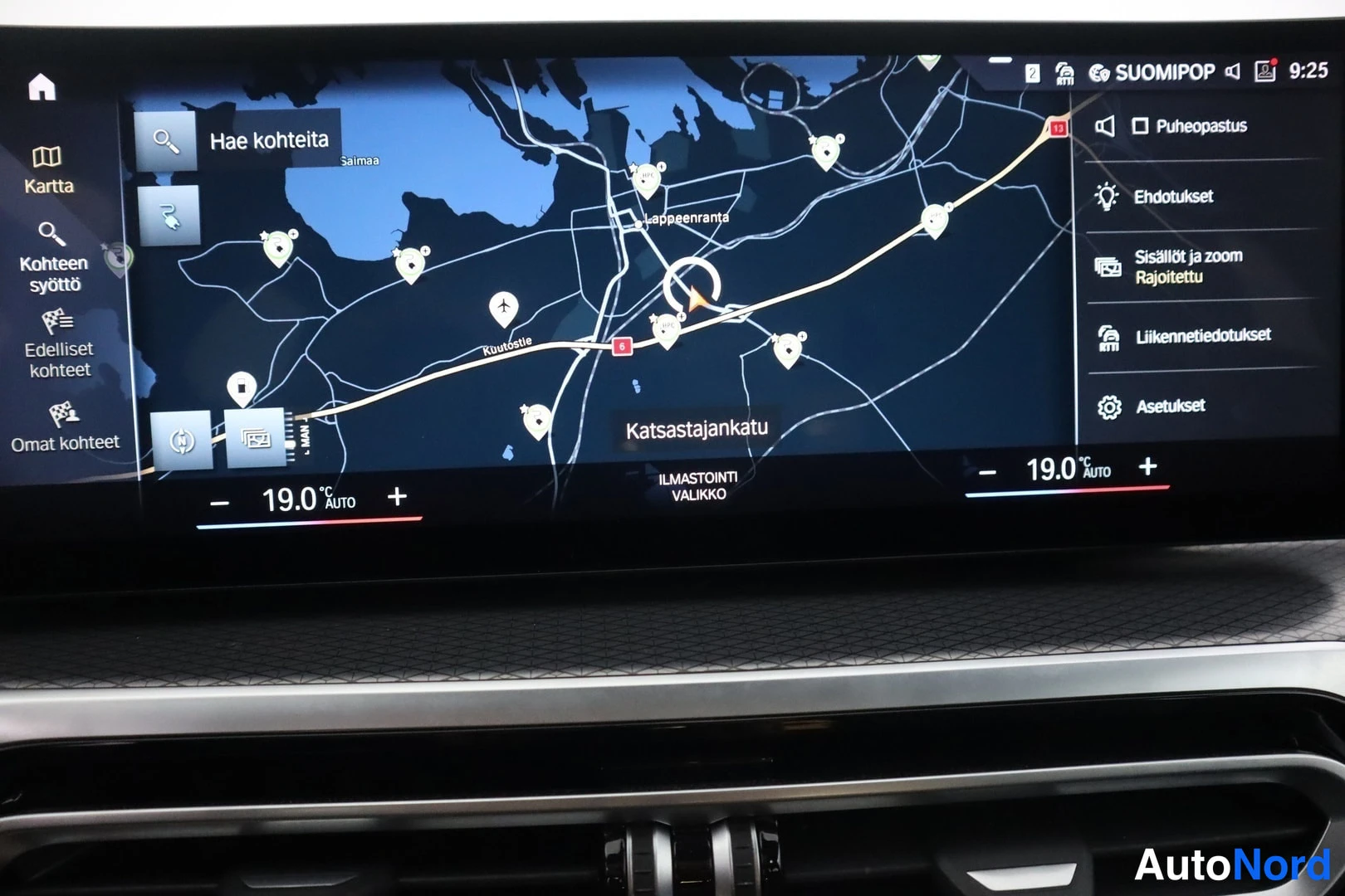 Yksityiskohta: Kojetaulun infotainment-näyttö karttanäkymässä, ilmastoinnin asetukset 19,0 asti molemmin puolin.