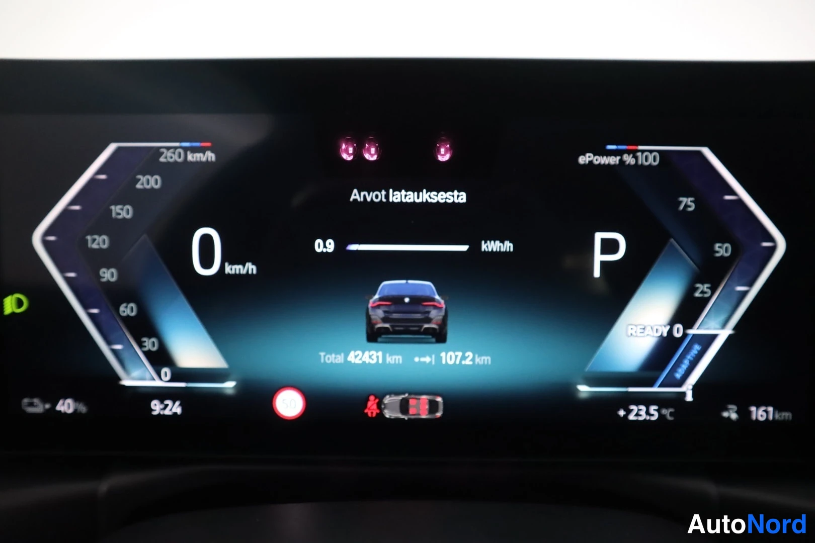Muu: Koeajomittarin näyttö: nopeus 0 km/h, vaihde P, kokonaismatka 42431 km, huoltomatka 107.2 km, lataustarve 0.9 kWh/h ja ePower 100 %.