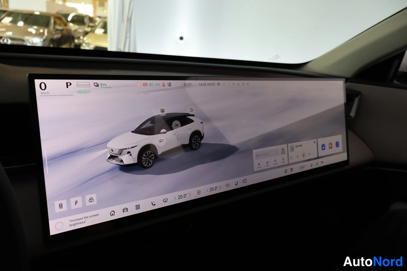 Ohjaamo: The vehicle's wide digital dashboard display is active, showing the infotainment interface. The screen displays a graphic of a white car with its roof visible,