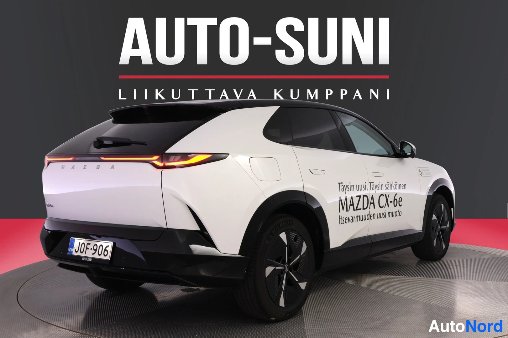 Takaviisto: Valkoinen Mazda CX-6e -porrasperä takakulmasta, perä vasemmalla, tunnus