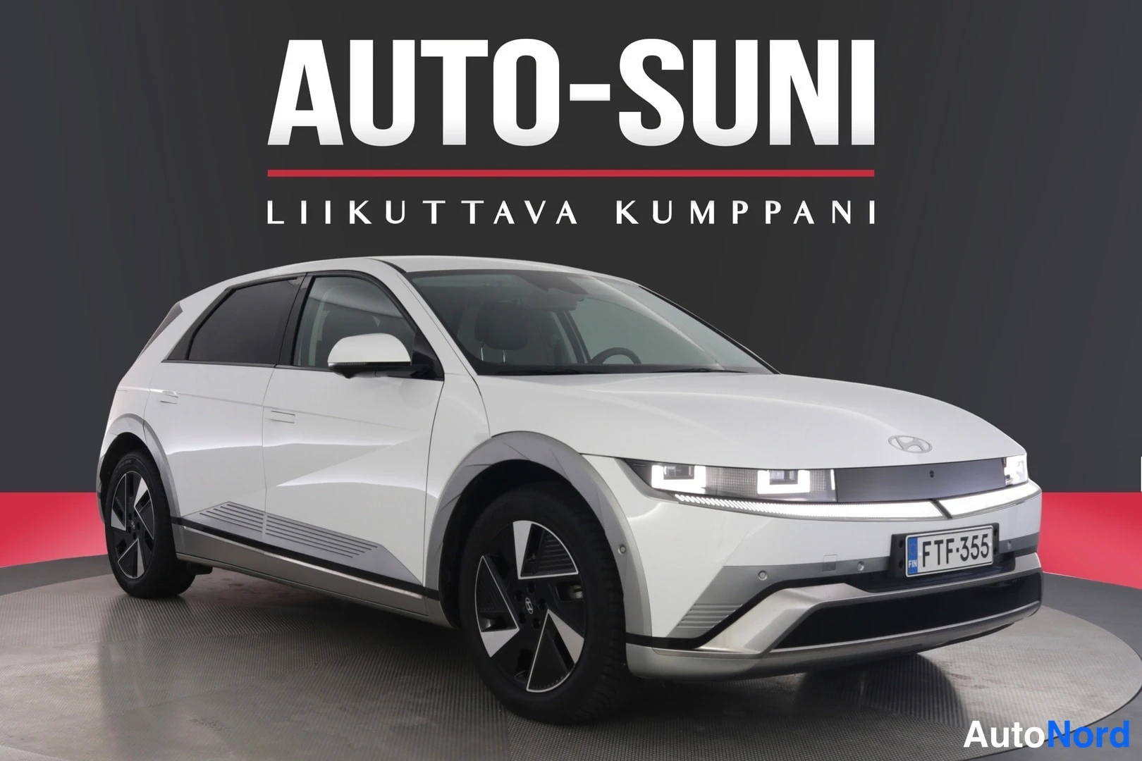 Etuviisto, nokka oikealle: Valkoisen hatchbackin etukulmanäyttö; rekisterikilpi.