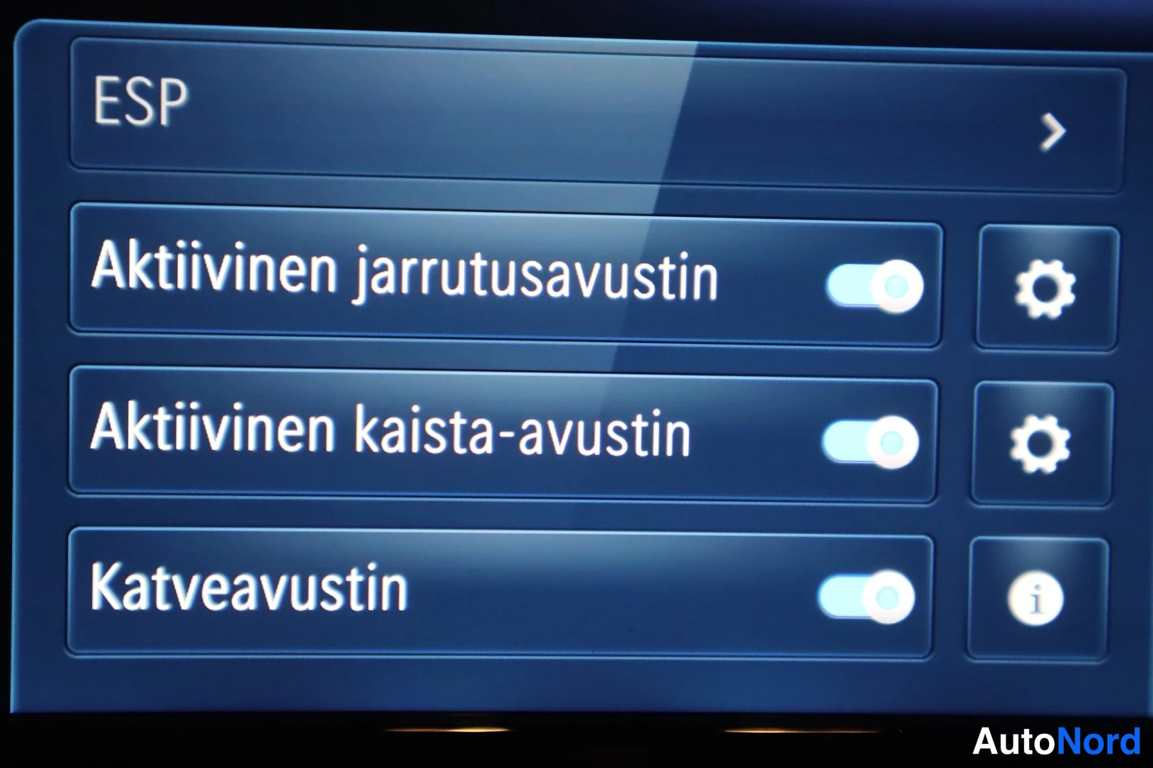 Yksityiskohta: Kuva infotainment-näytön ESP-asetukset-valikosta, jossa näkyvät päälle asetetut toiminnot: Aktiivinen jarrutusavustin, Aktiivinen kaista-avustin ja Katveavustin